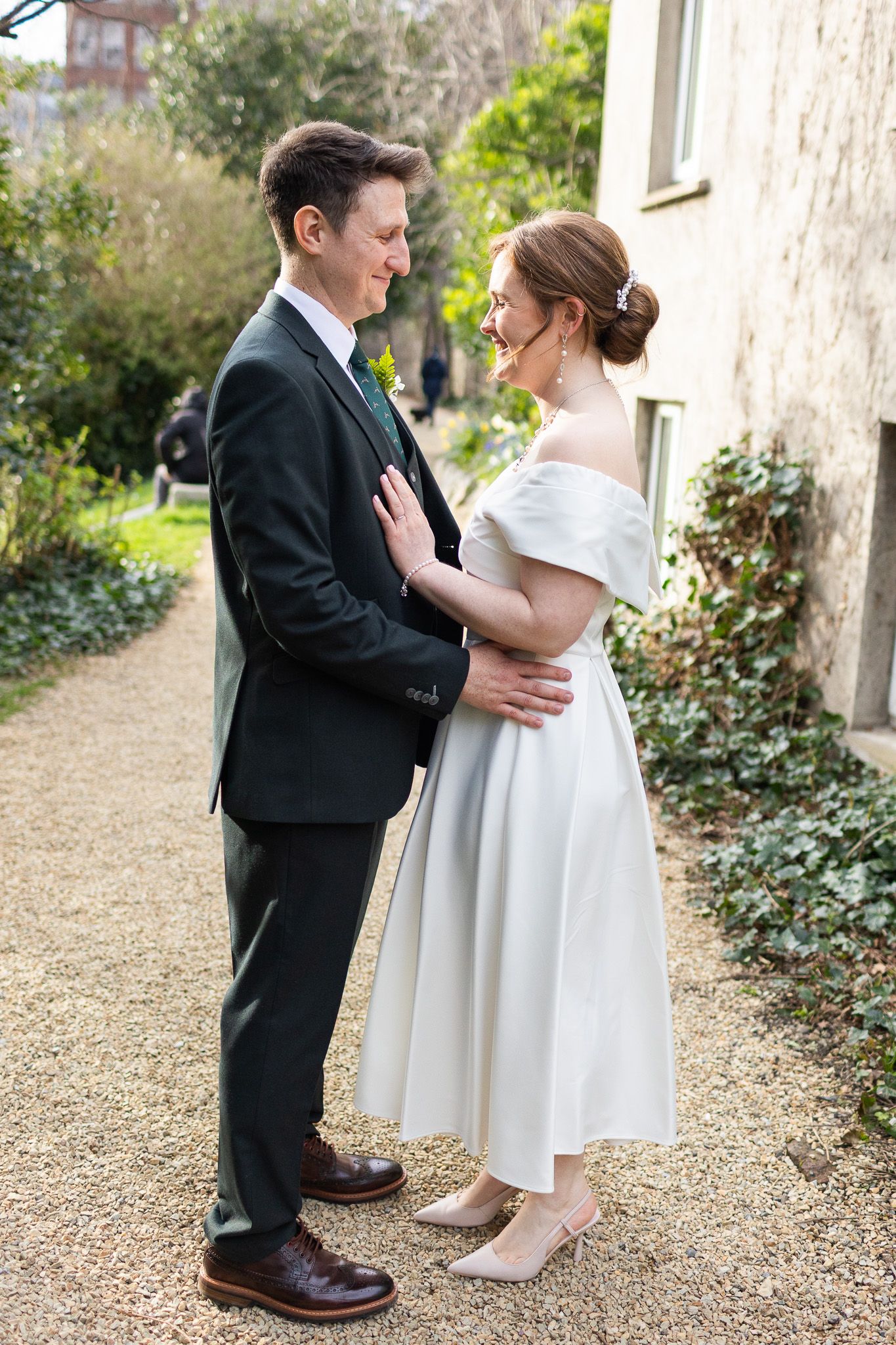 Romantic Dublin City wedding photos taken on a garden path with stone walls and greenery.