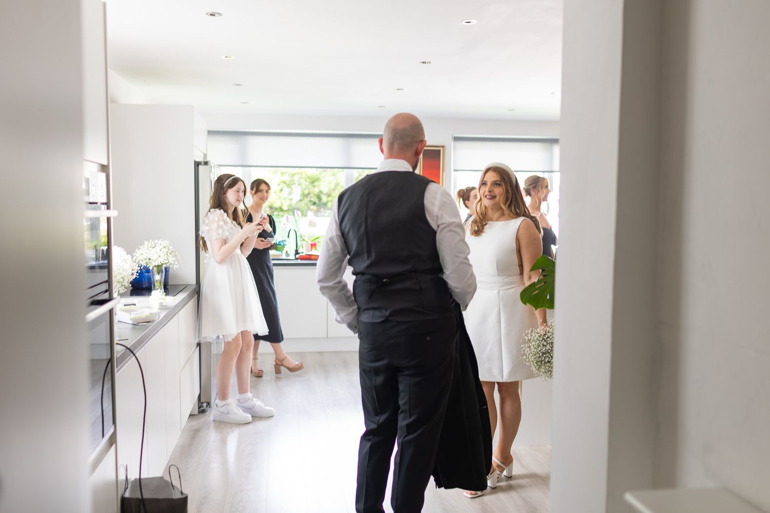 White hallway interior showing people moving through modern space during an event.