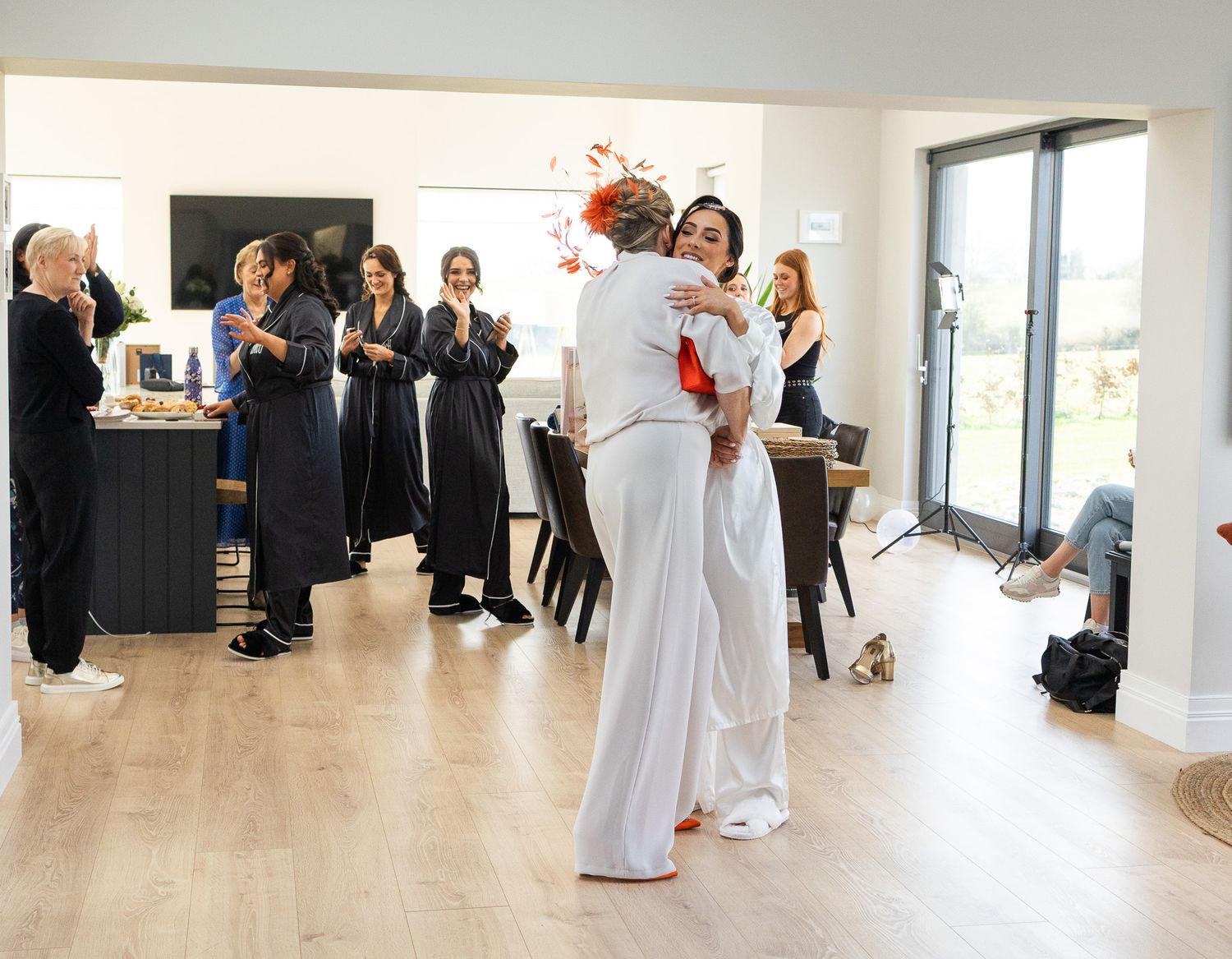 Wide panoramic view of a bright modern event space with white decor and hardwood floors During weddings prep.