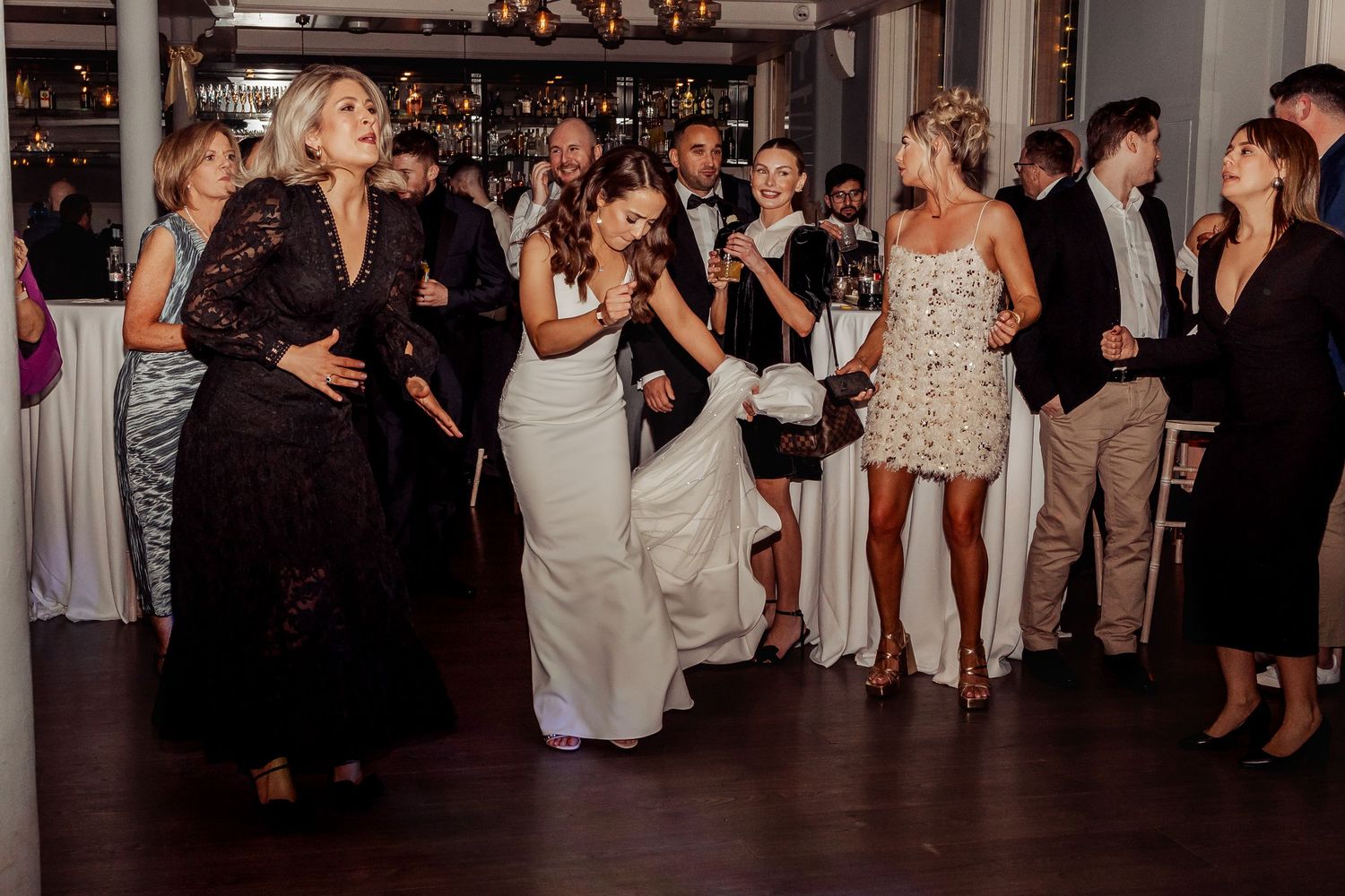 Wide view of wedding reception dance floor with guests celebrating.