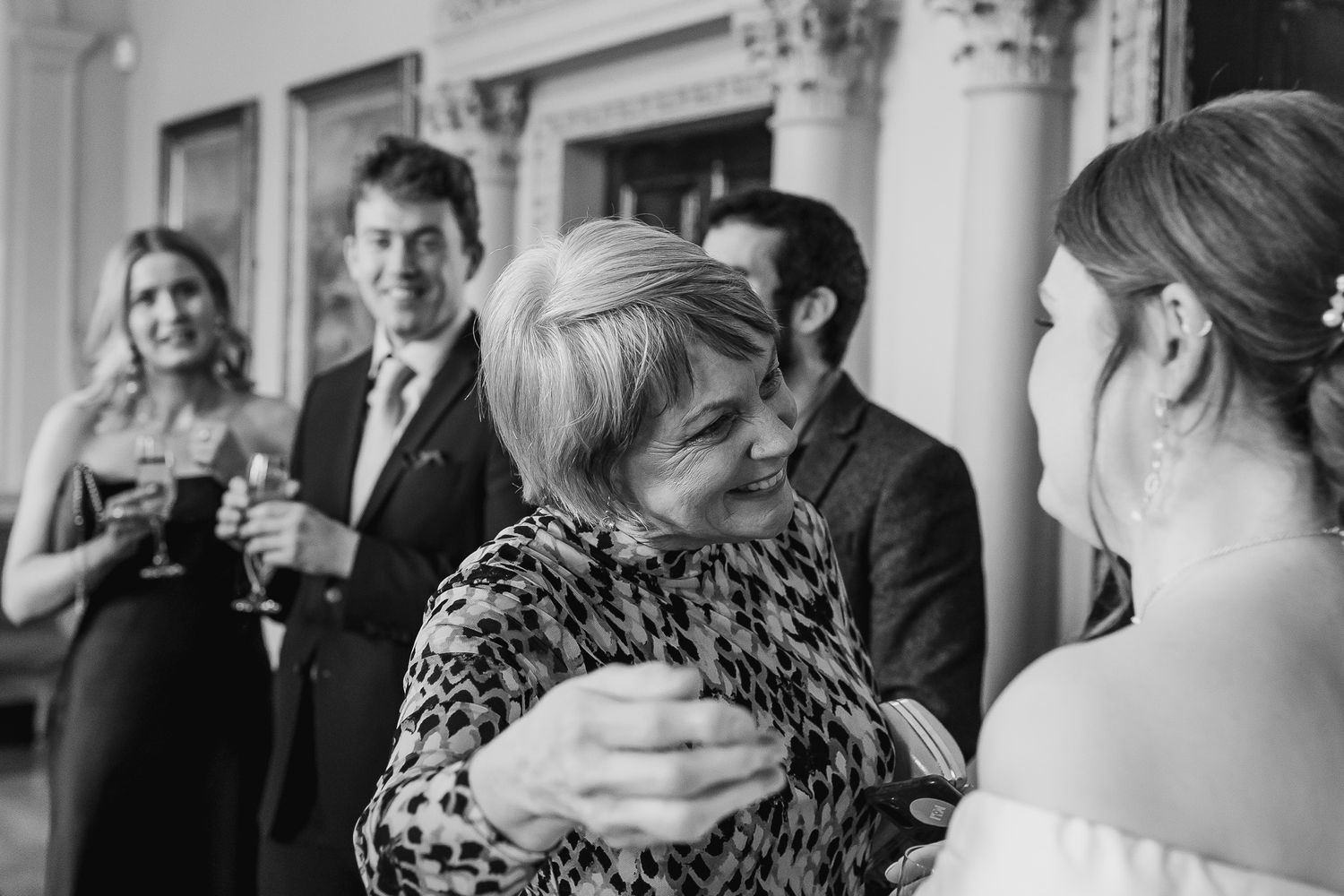 Dublin Wedding reception guests celebrate in an ornate room with classical architecture.