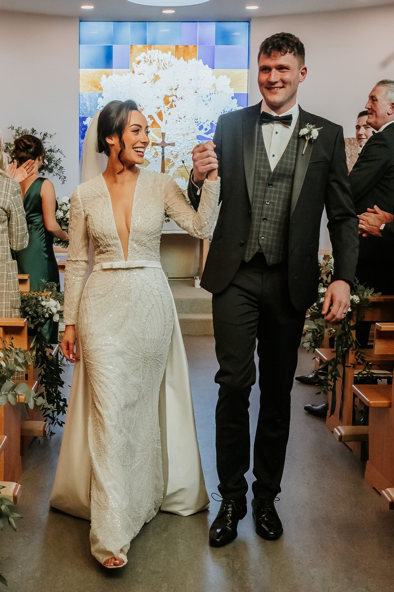 Couple shares joyful moments in a modern reception venue with decorative wall art.