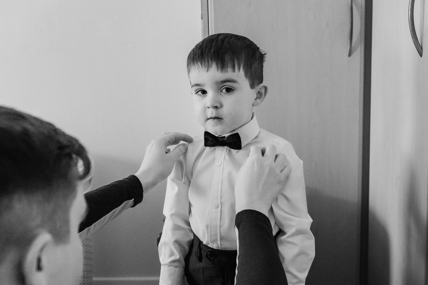 Black and white portrait of young ring bearer in formal attire.