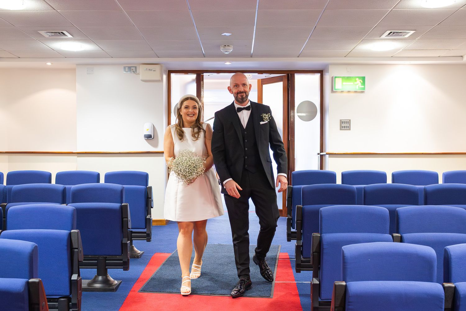 Dublin Wedding ceremony venue with red carpet and blue theater seating. Captured by Dublin Wedding photographer Laura Conlon