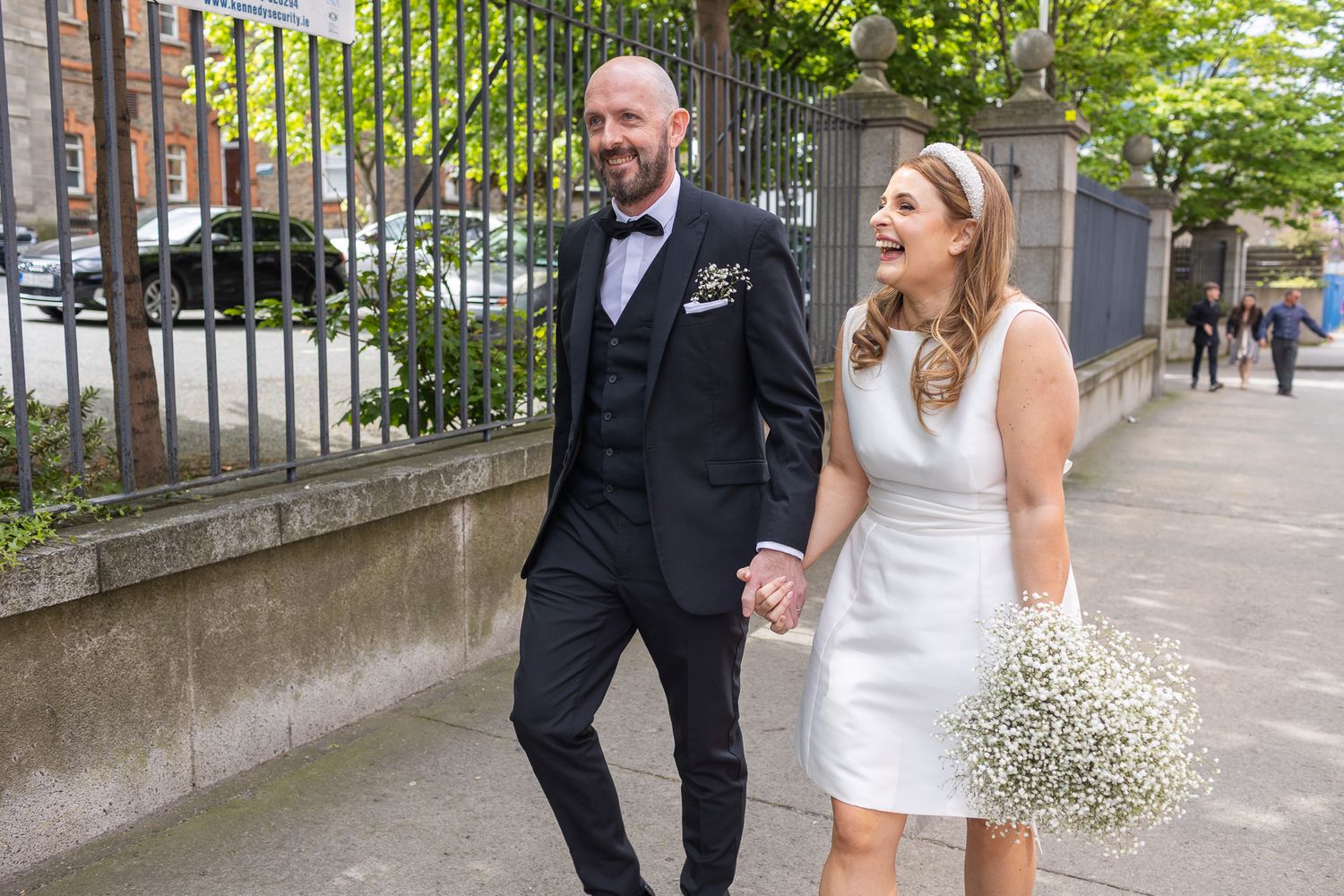 Wedding party walks together outside Dublin Registry office on a sunny day.