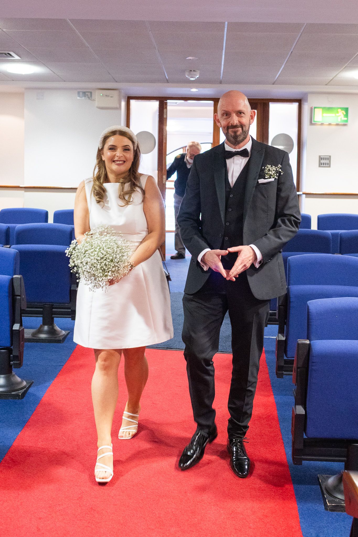 Bride and groom walking down a red carpet aisle of Dublin registry office