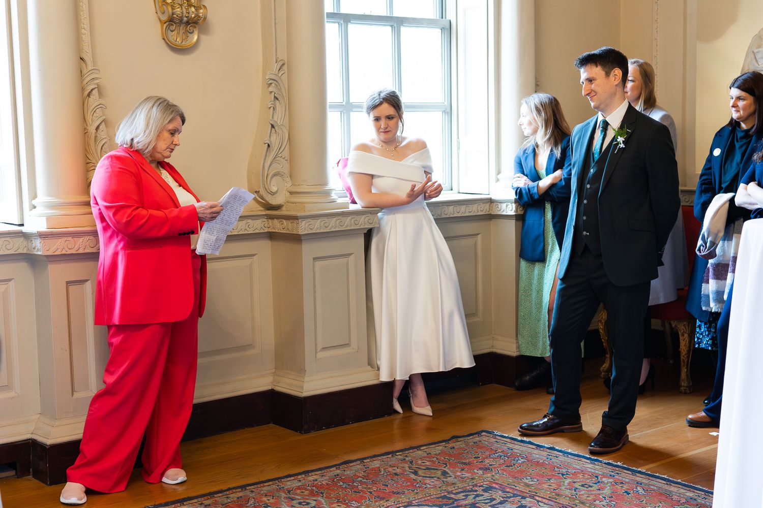 A Dublin wedding ceremony in a bright MoLI  room with a person in a red suit officiating.