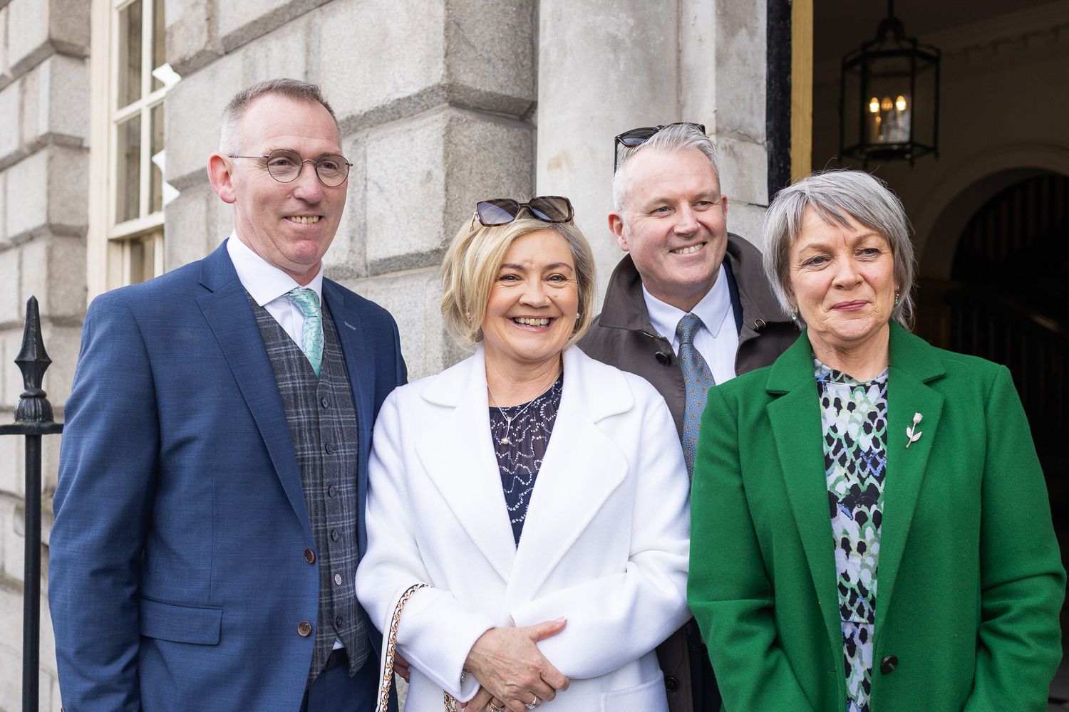 A group of formally dressed people pose together outside Dublin City MoLI.
