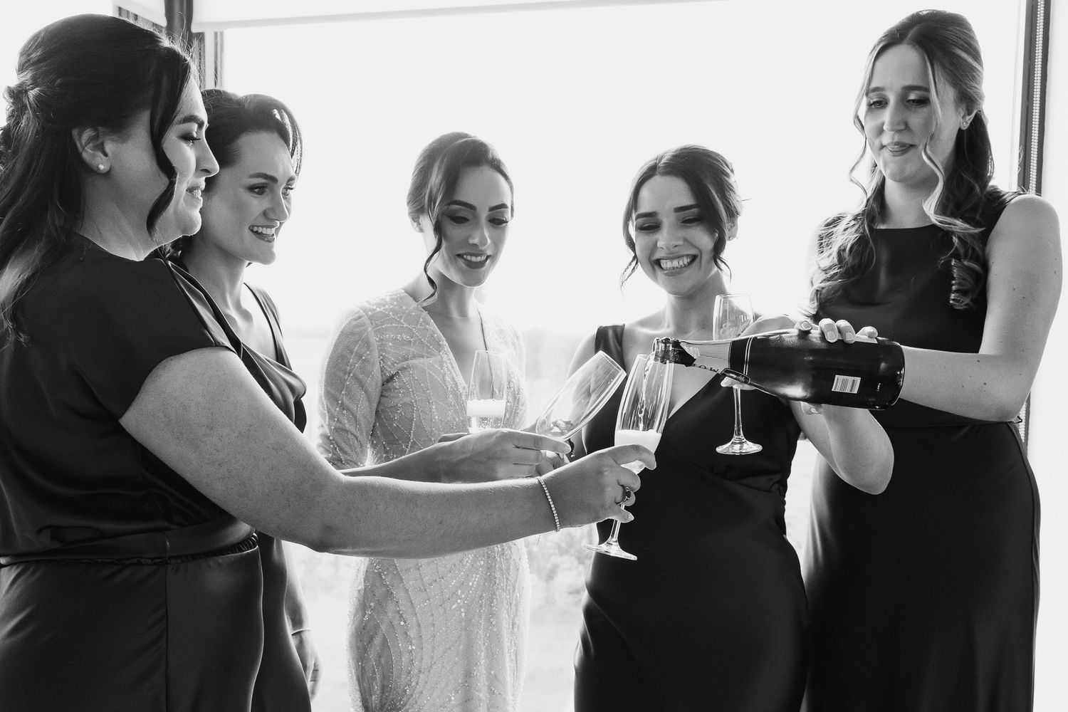 Bridal party preparing for special event by window taken by Wedding photographer