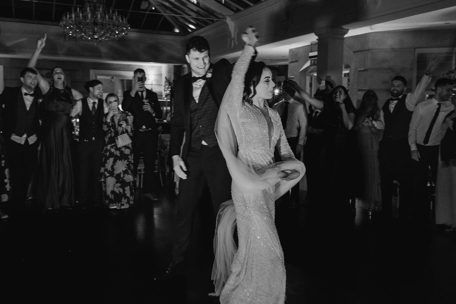 Black and white panorama of wedding guests dancing and celebrating on a lively dance floor at Fallon & Byrne wedding.