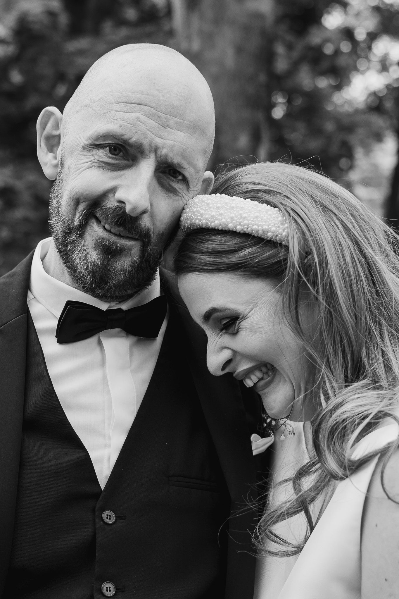 Intimate black and white portrait captures tender moments between a couple on their wedding day.