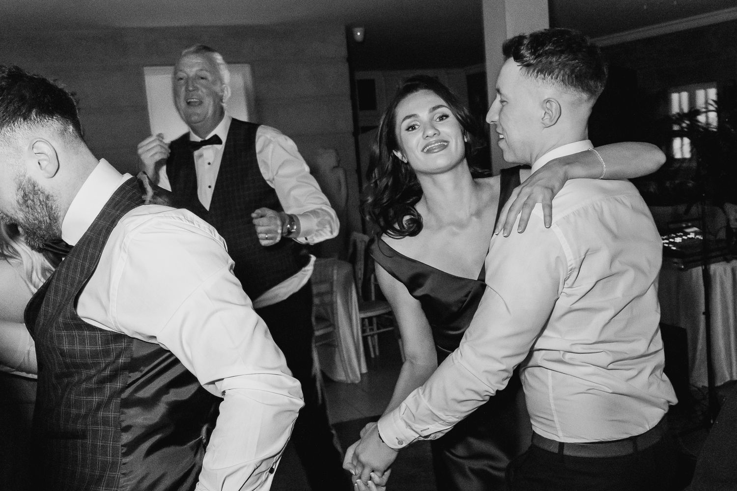 Dublin wedding guests dancing and celebrating together at an indoor reception party.