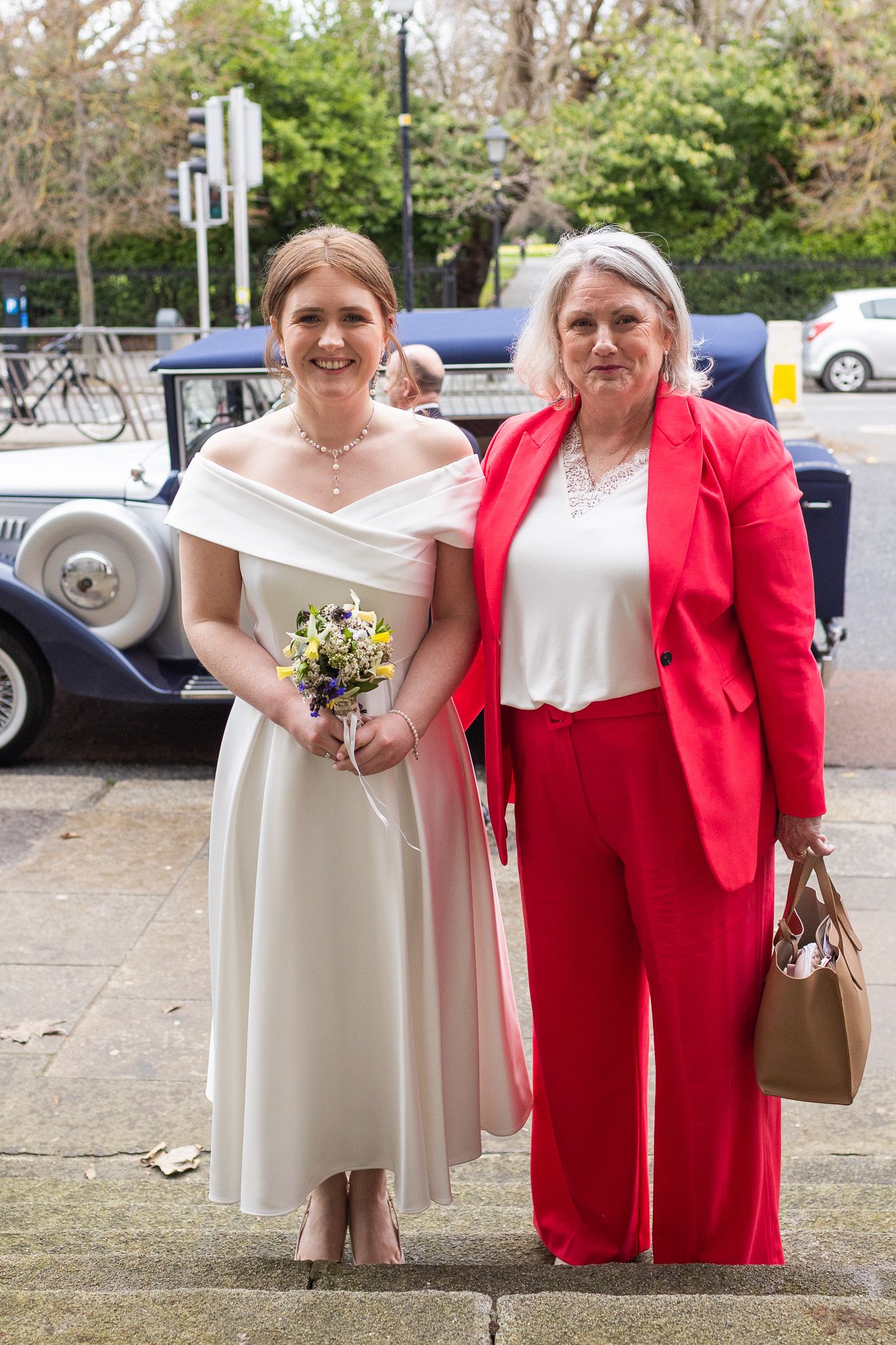 Dublin wedding party members in white and red attire pose together outside the MoLI  in Dublin city.