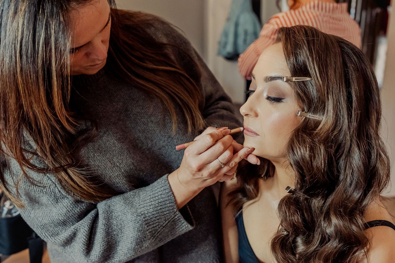 Close-up shots of a bride getting her makeup professionally applied during wedding preparations.