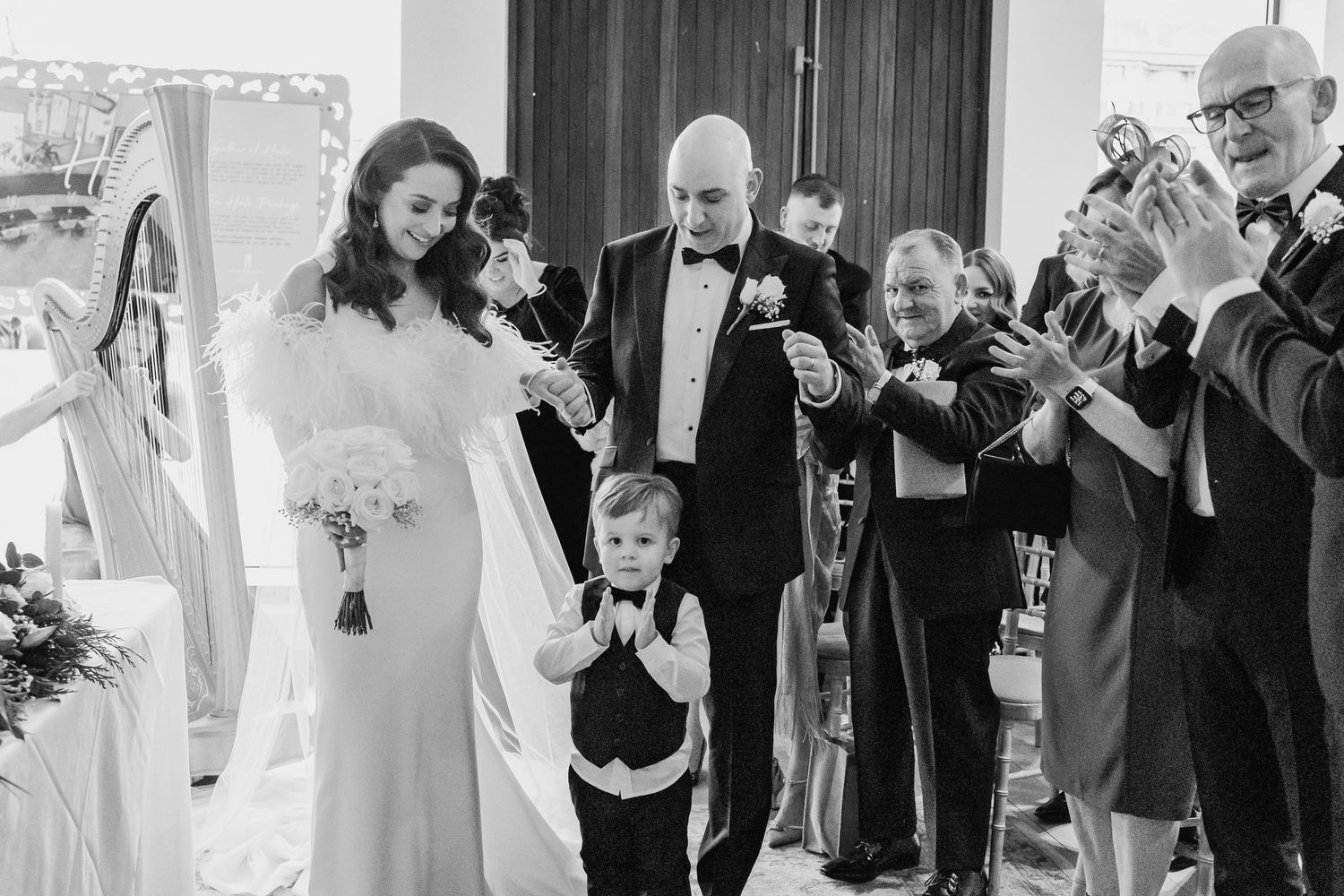 Wedding party members share candid moments during an indoor reception.