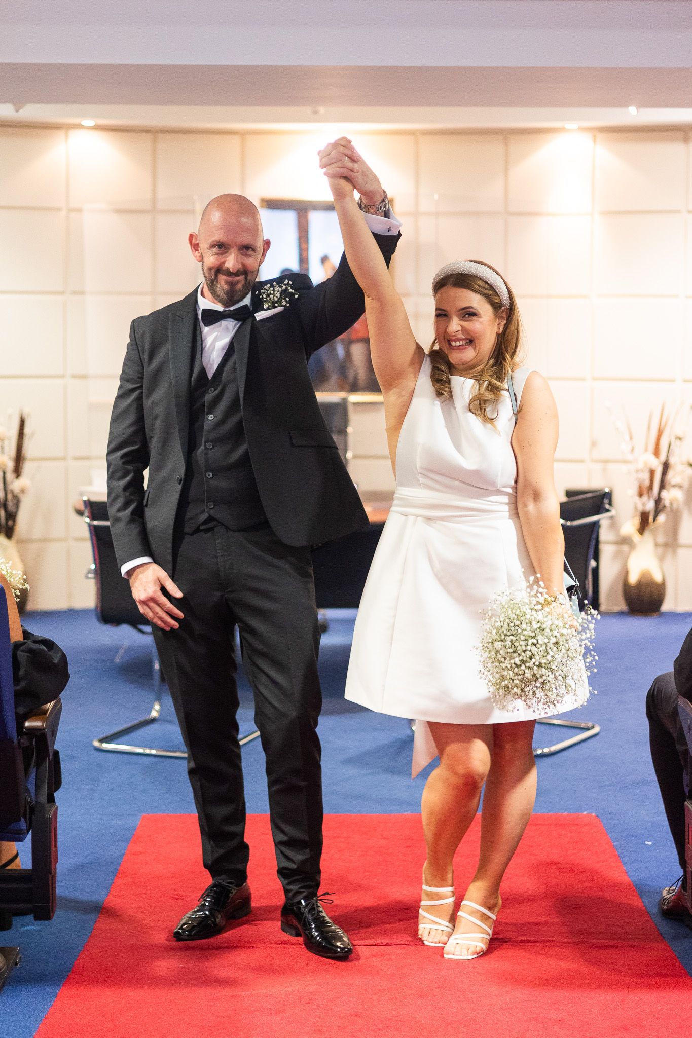 Wedding party members' feet and legs shown on a red carpet after relaxed wedding ceremony in Dublin Registry office.
