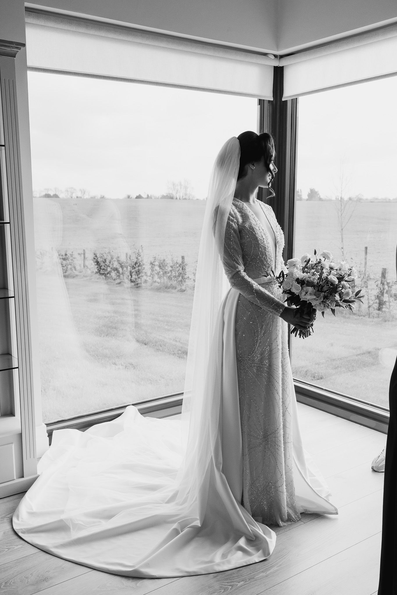 Elegant bridal silhouettes captured against large windows overlooking Dublin city views.