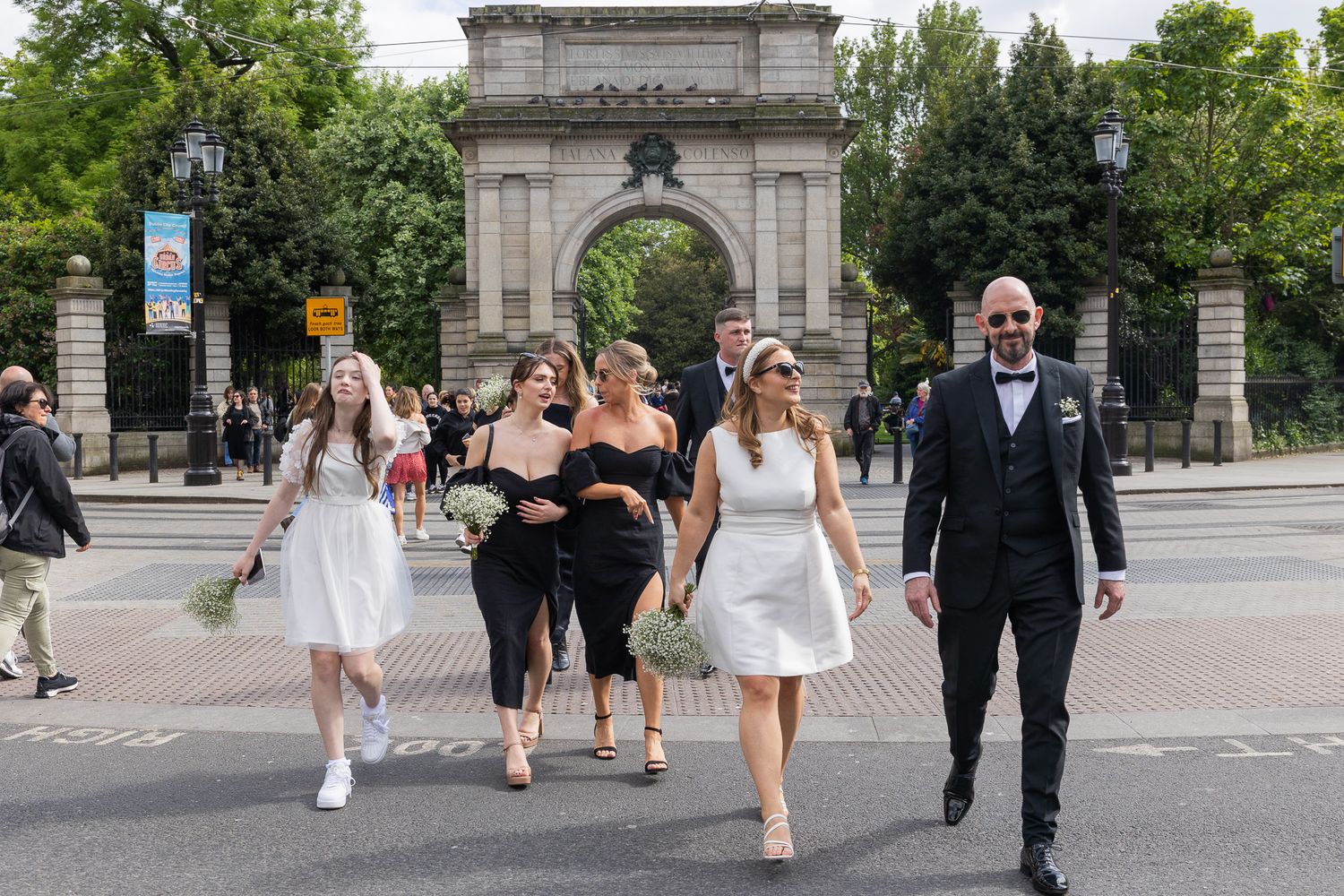 Wedding party walking together through Dublin city streets in formal wedding attire..