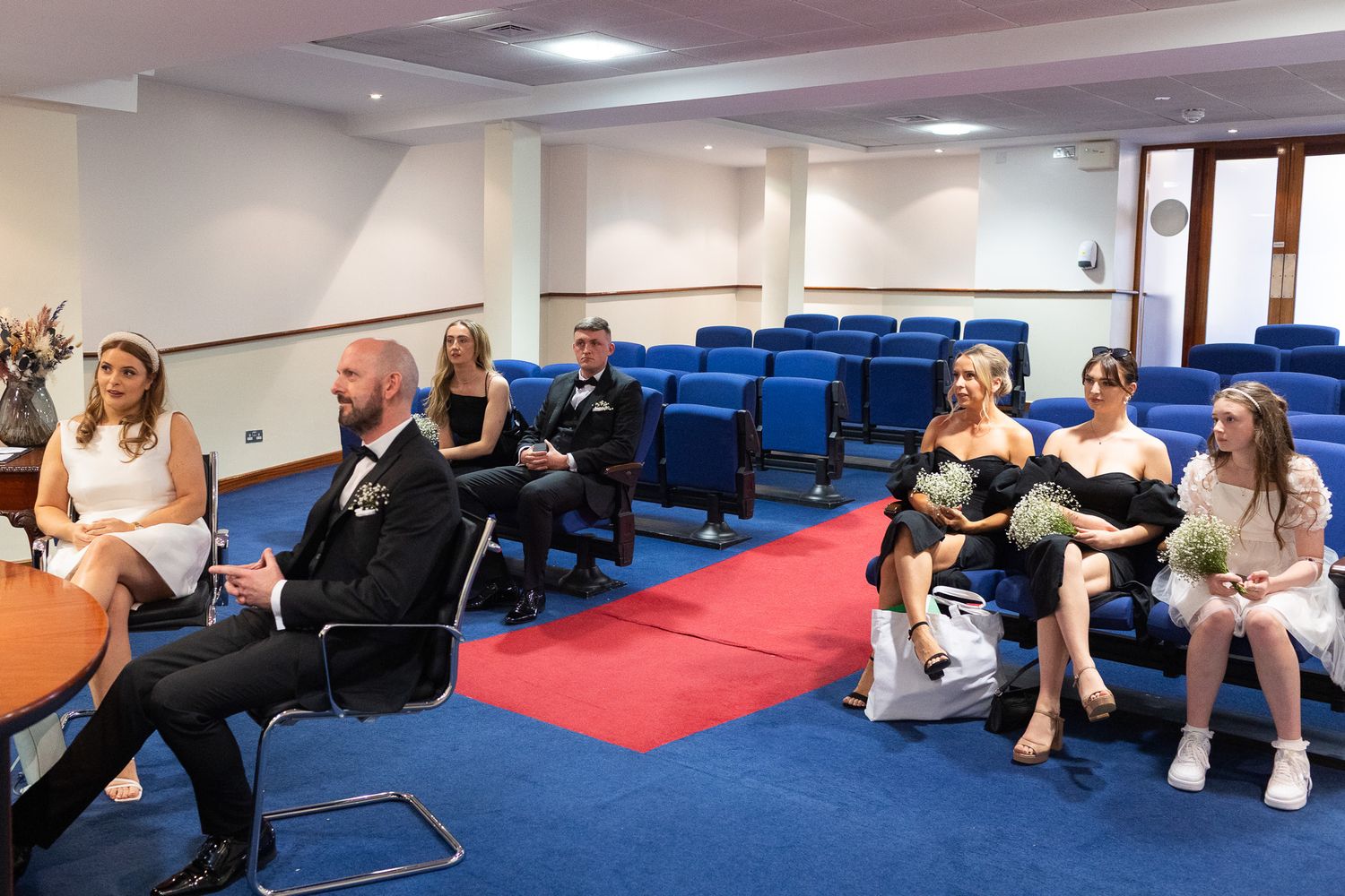 Wedding guests seated in blue chairs during Dublin registry office ceremony.