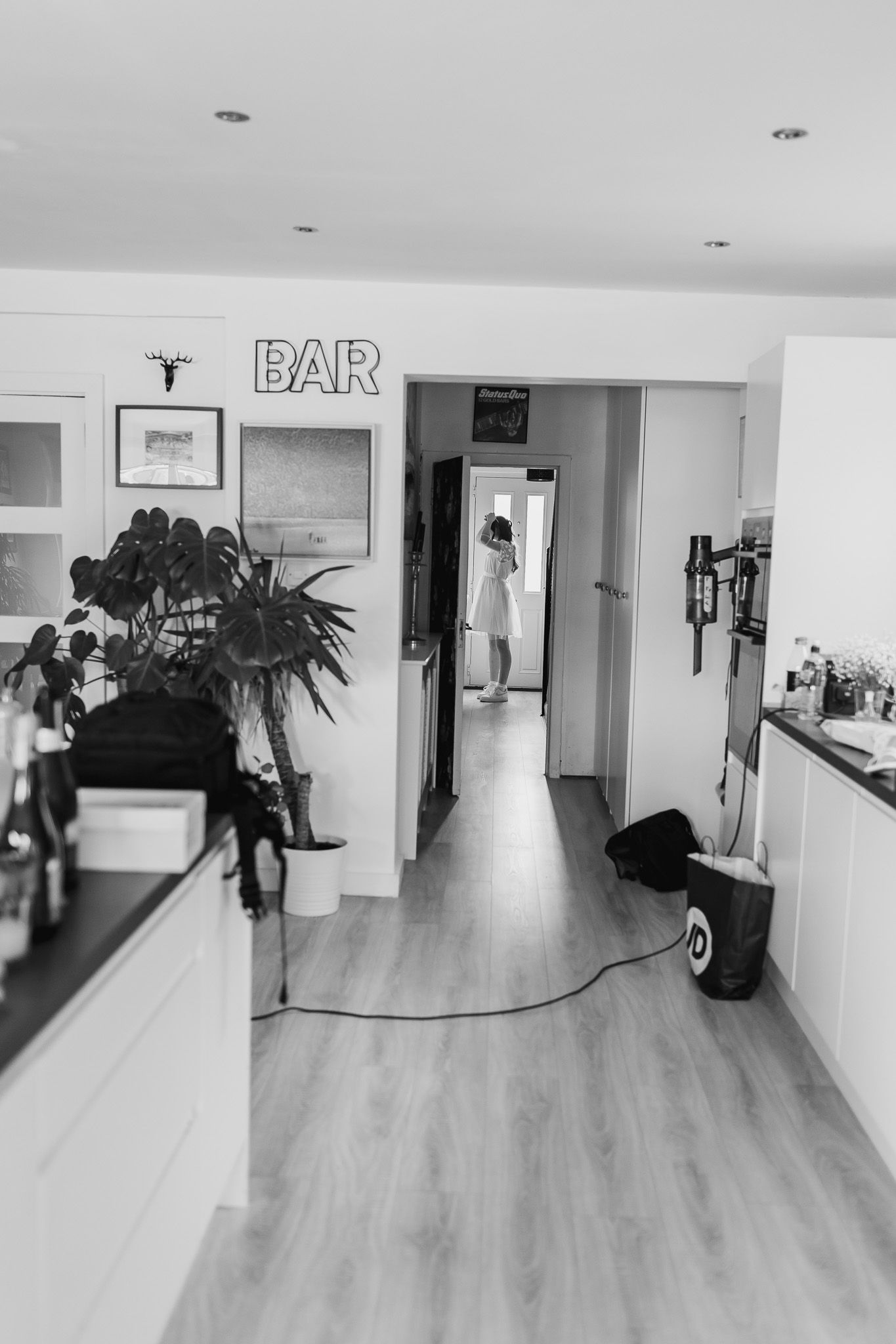 Black and white hallway photos showing movement through a modern interior space with a bar sign.