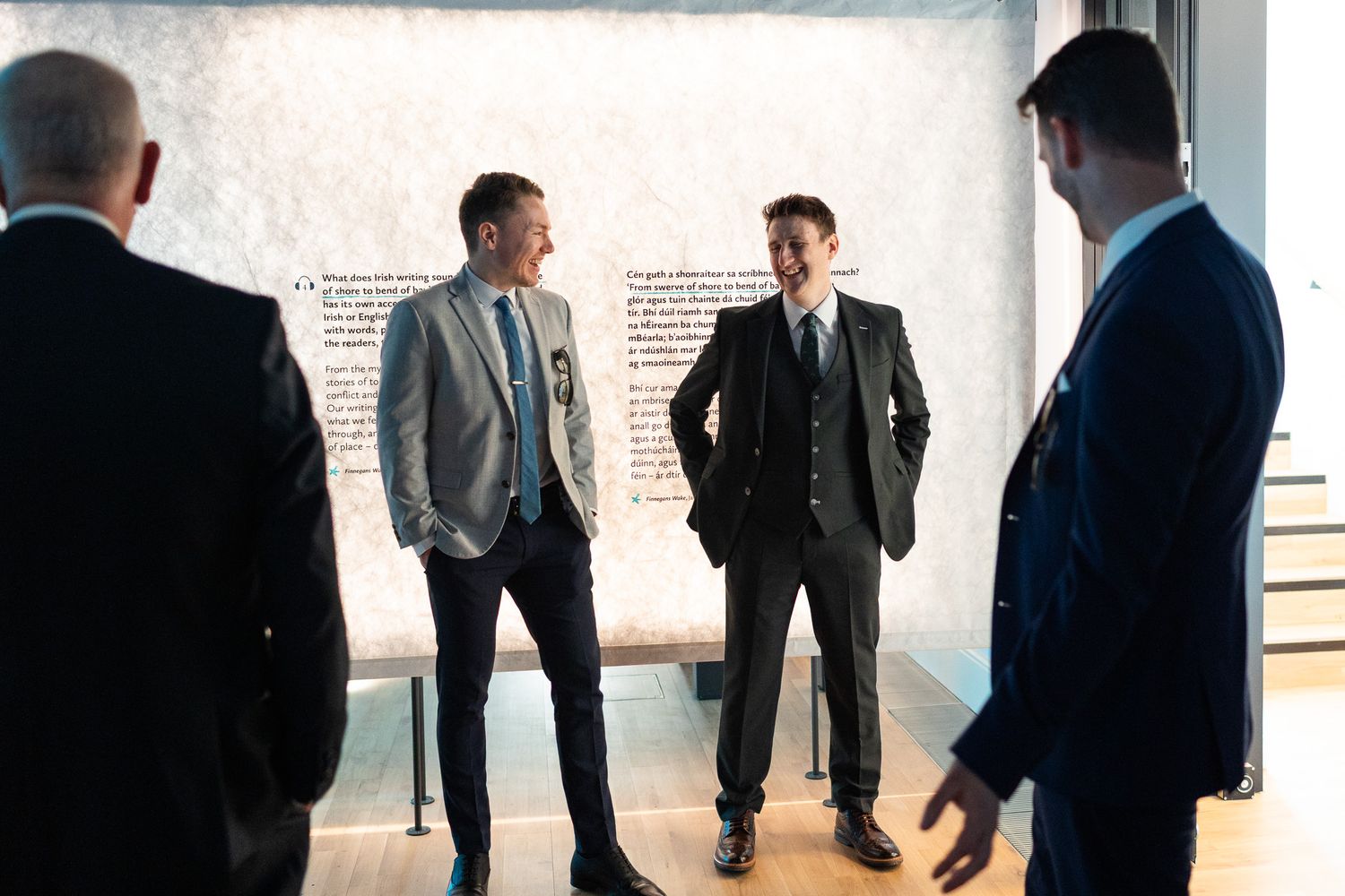 A group of men in suits having a conversation in a bright indoor space at Dublin's MoLI  .
