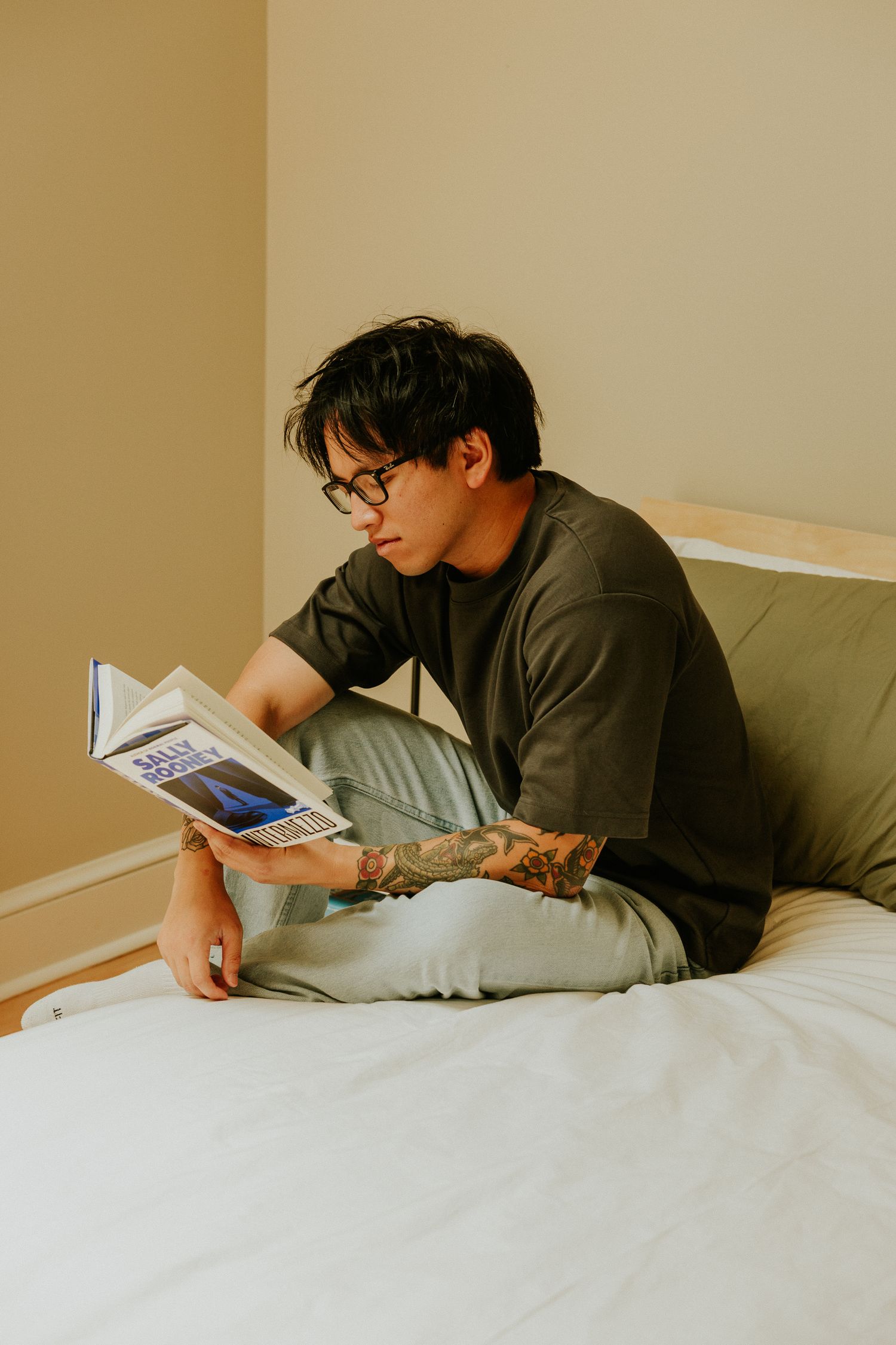 Man sitting on a Floyd bed reading a book, Shot by Dylan Spangler