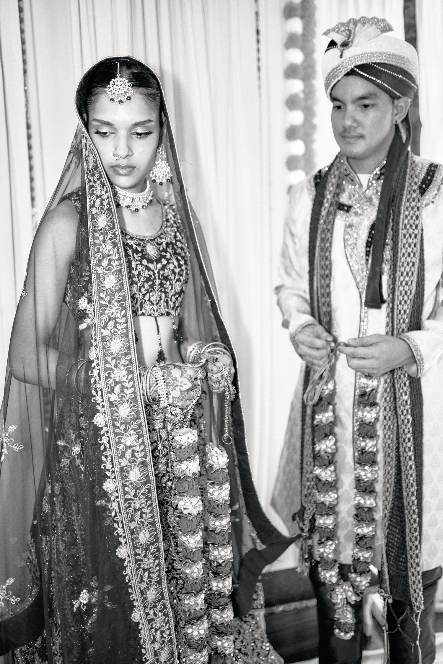 Black and white series showing traditional Indian wedding ceremony with garlands and ceremonial attire.