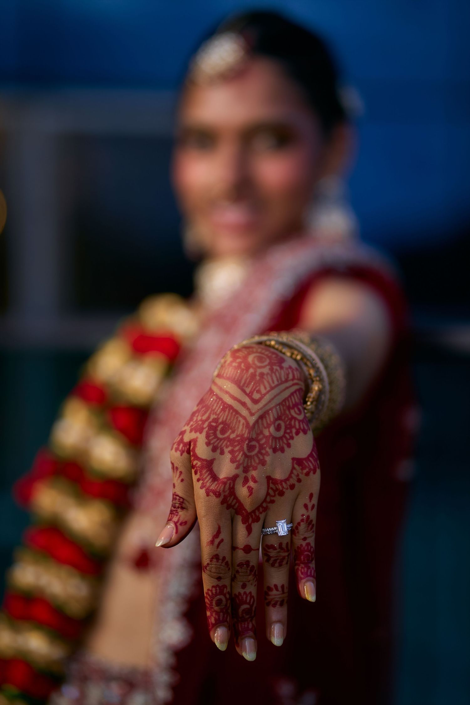 Close-up detail of intricate henna designs on hands with blurred background.