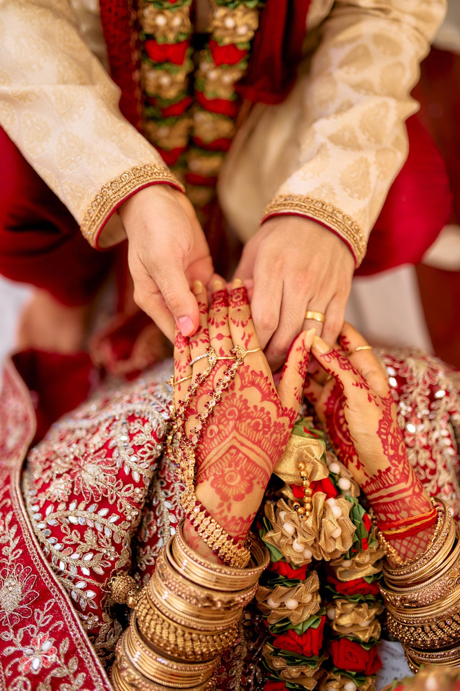 Detailed shots of hands with mehndi designs and wedding bangles during an Indian ceremony.