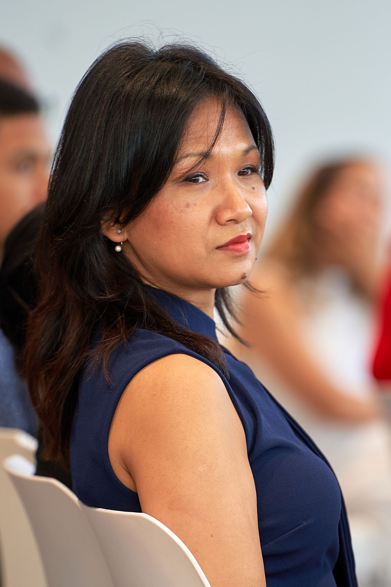 A series of profile shots showing a person with dark hair wearing a navy sleeveless top looking over their shoulder.