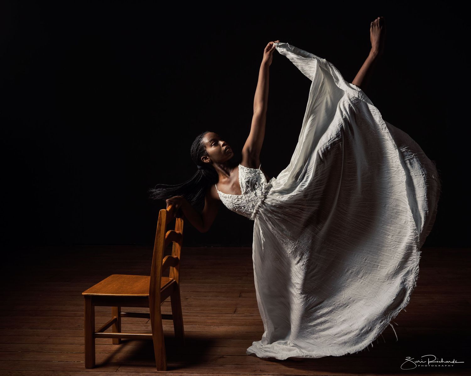 Dramatic dance sequence showing flowing white dress movement in low light on wooden floor.