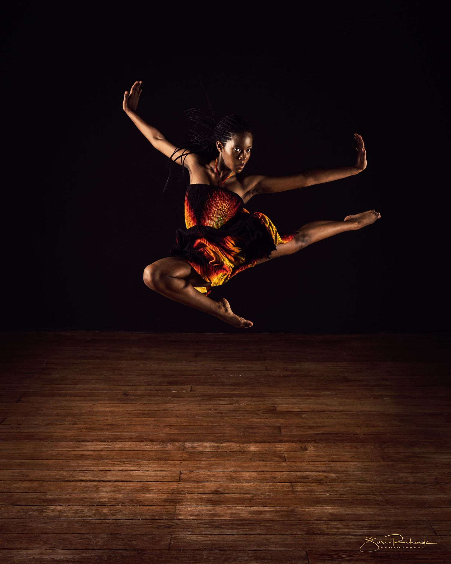 Dynamic dance sequence capturing aerial movements and leaps on wooden stage.