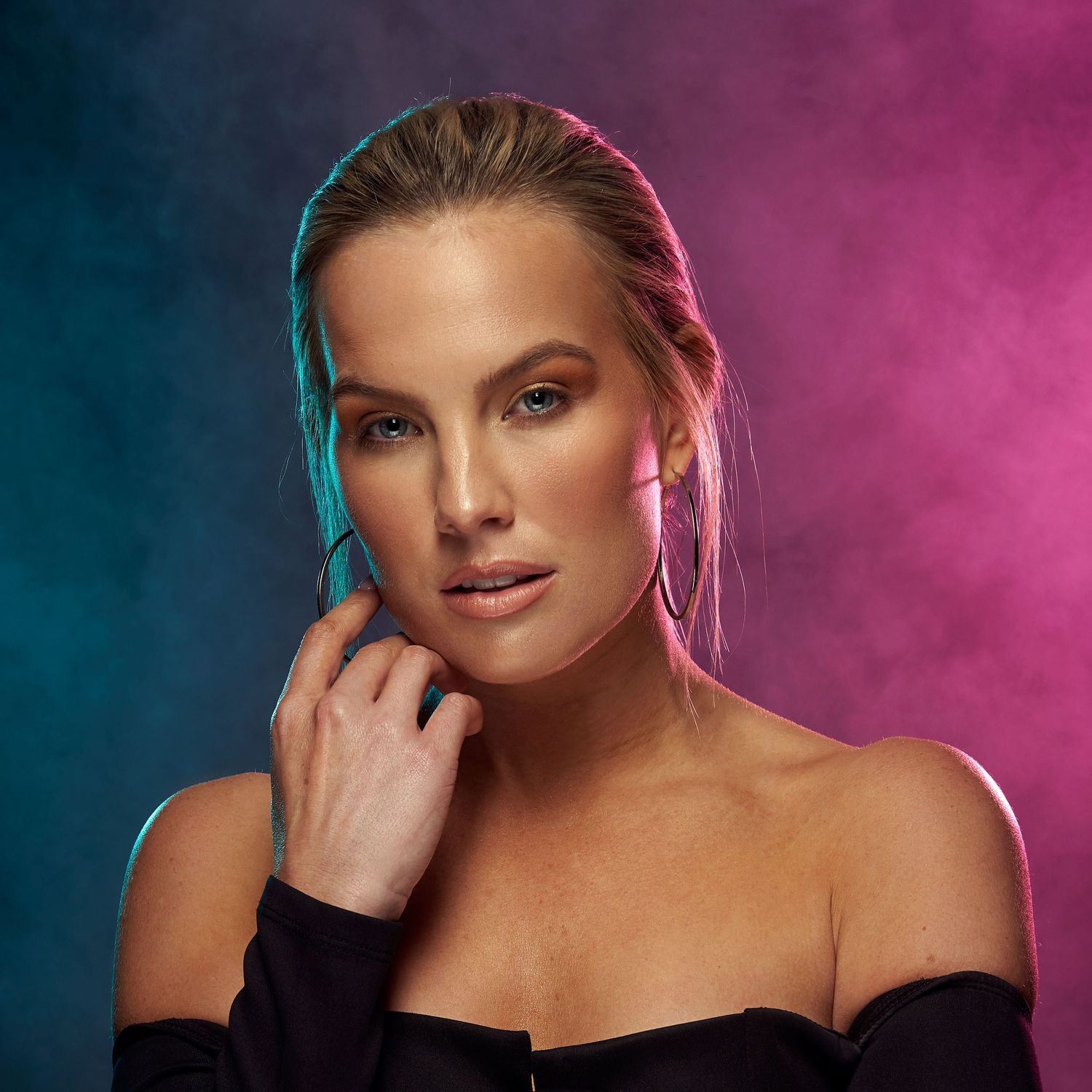 Studio beauty portrait with colorful pink and blue smoke effect background.