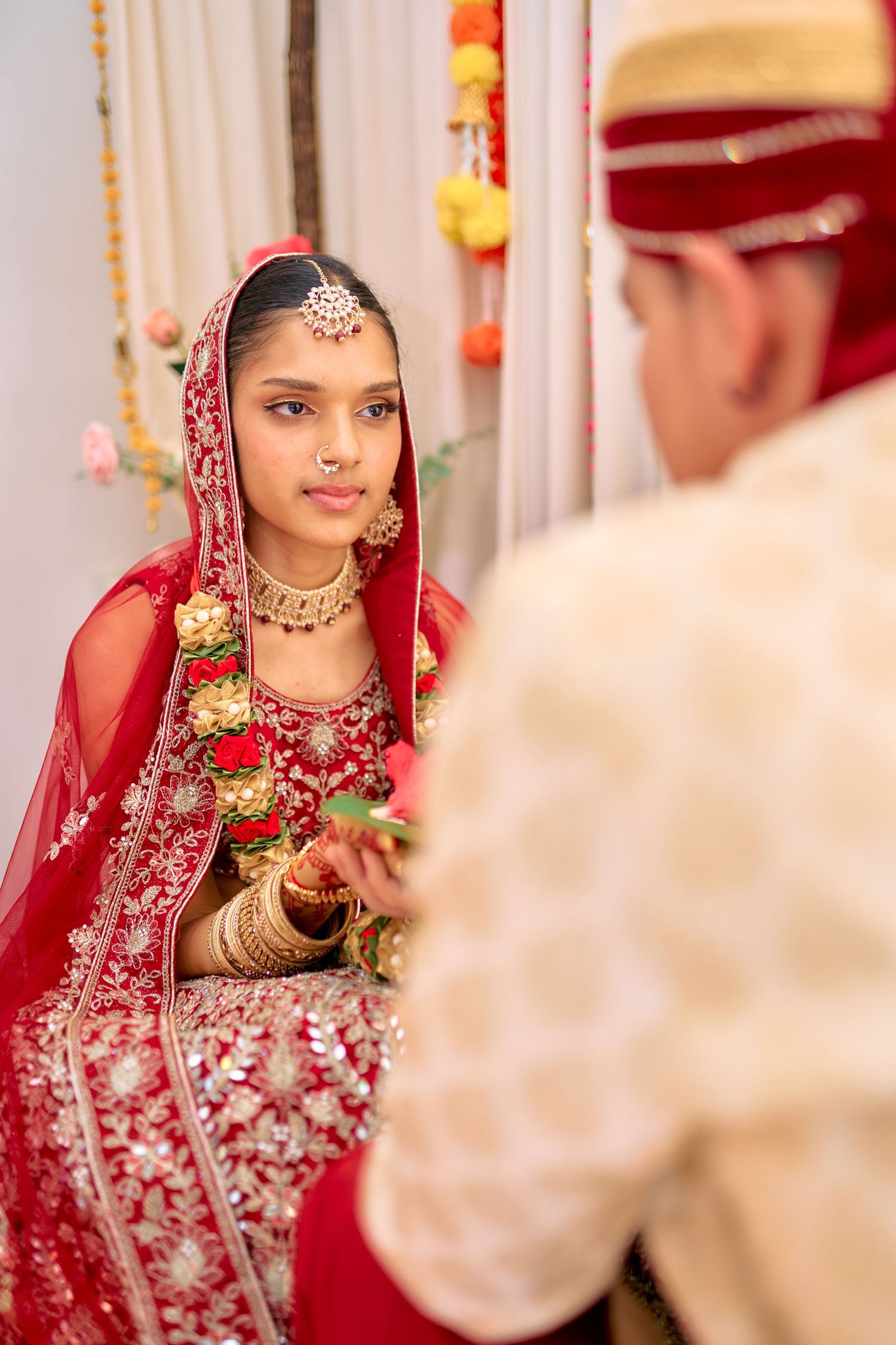 Traditional Indian wedding ceremony showing detailed shots of bride in red and gold embroidered attire.