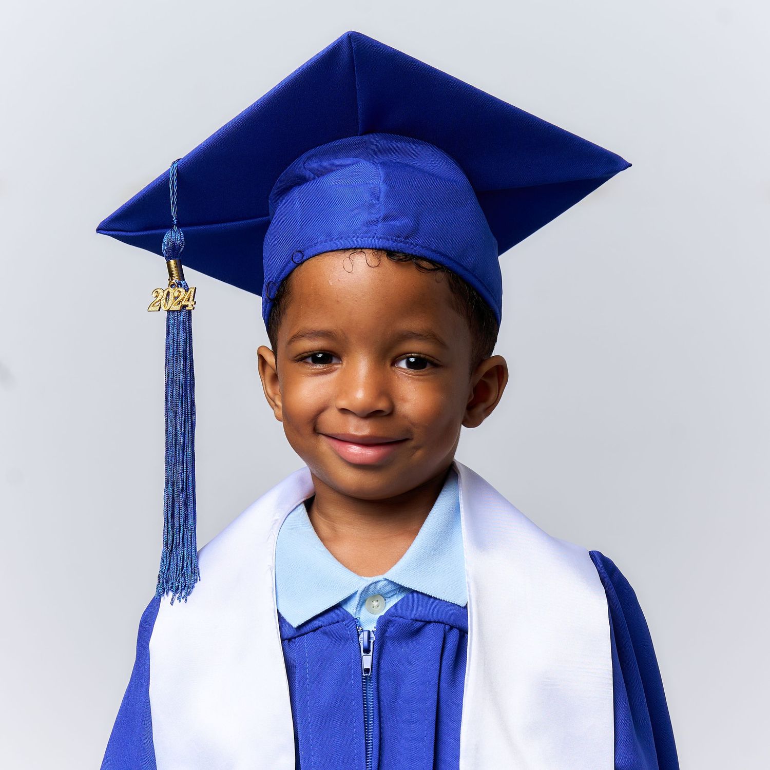 Graduate in royal blue cap and gown poses for a series of celebratory portraits against white background.