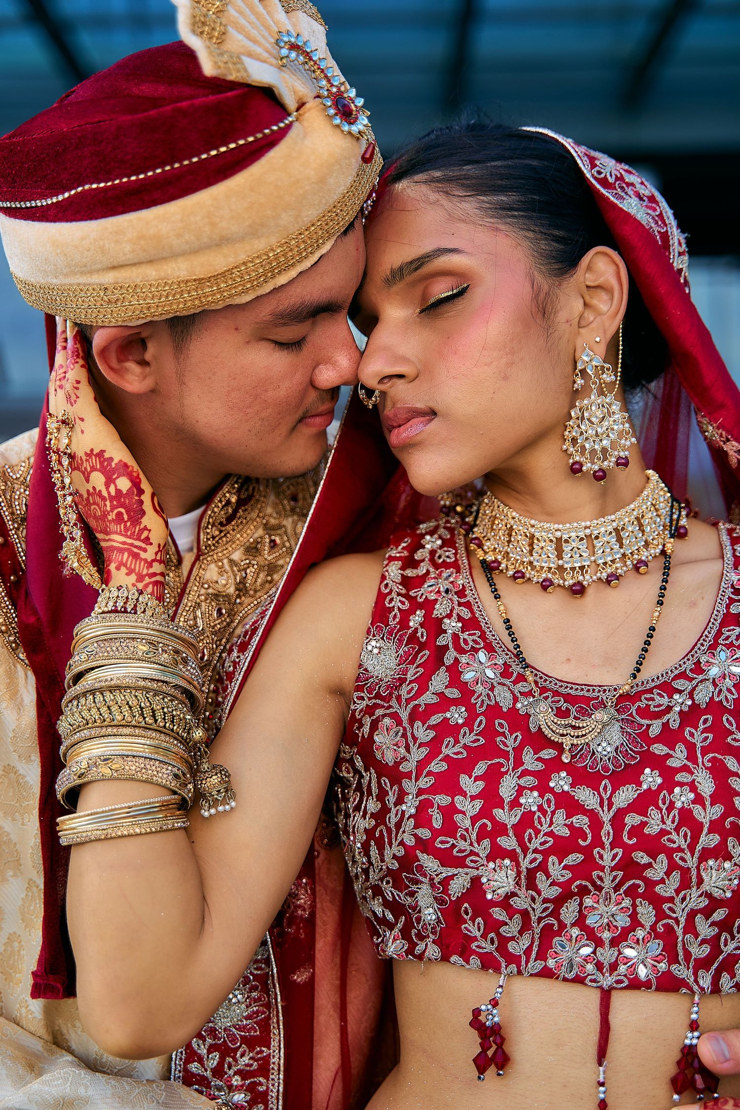 Close-up shots of couple in ornate Indian wedding jewelry and attire sharing intimate moments.