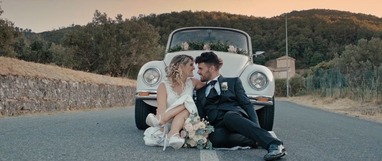 Alberto & Maria, bride and groom sitting by a vintage Beetle at sunset during their wedding in Davoli, Calabria, Italy
