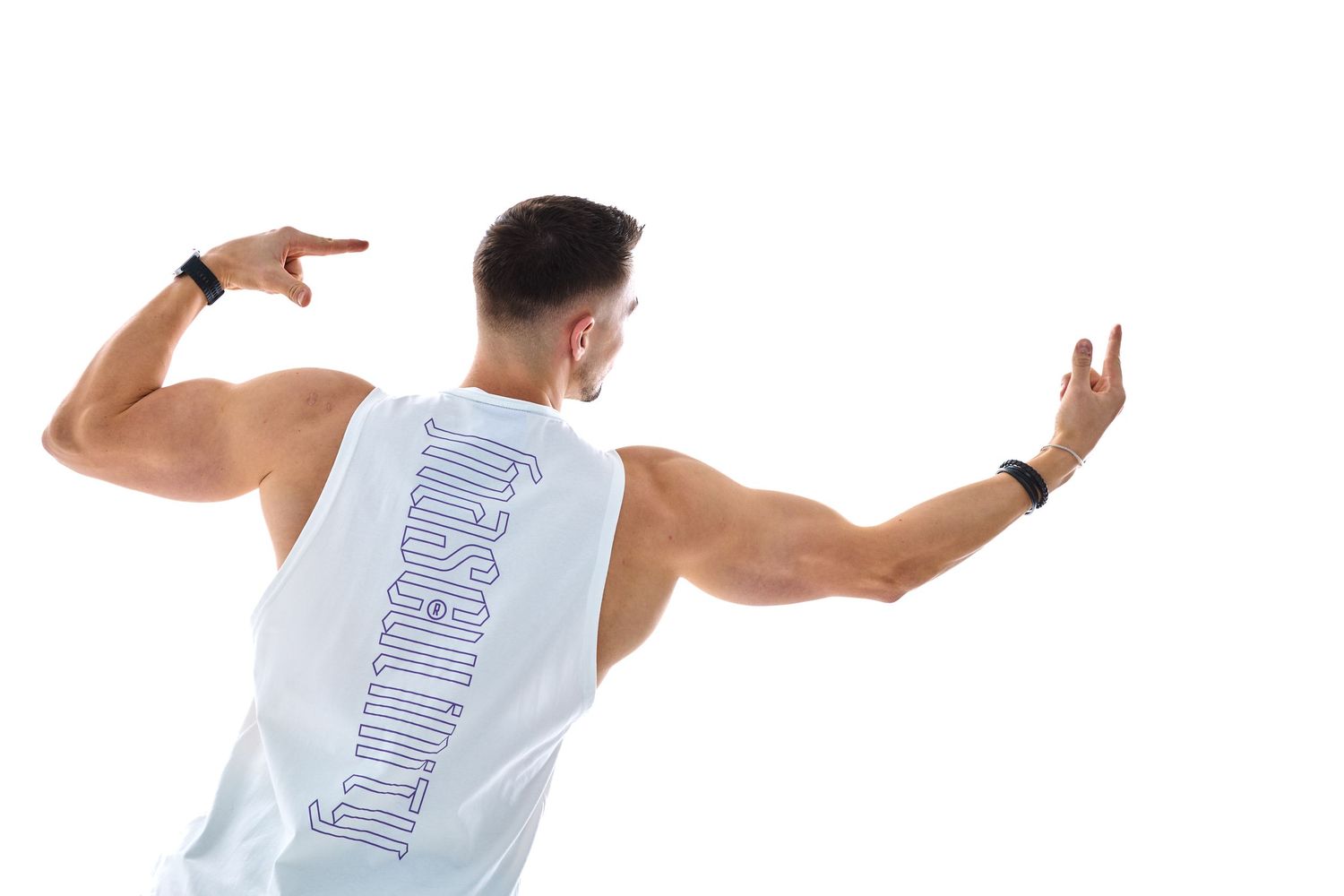 Muscular man in white sleeveless gym tank top pointing to back logo, showing athletic physique against white background.