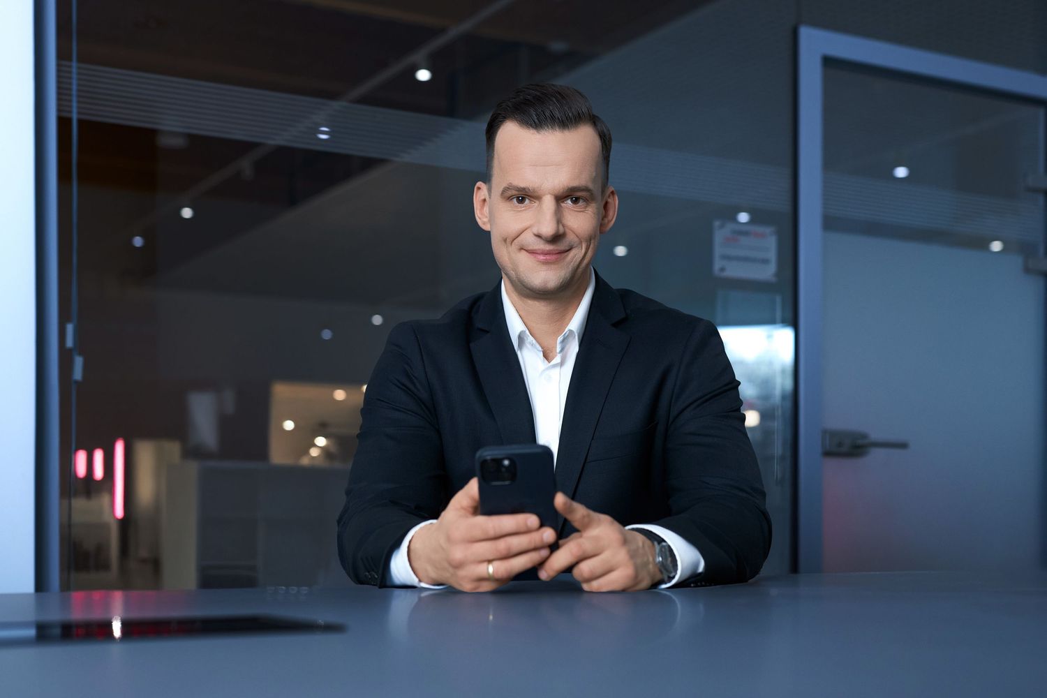 Profesjonalista biznesowy korzysta ze smartfona w nowoczesnym biurze. Fotografia biznesowa Lublin.