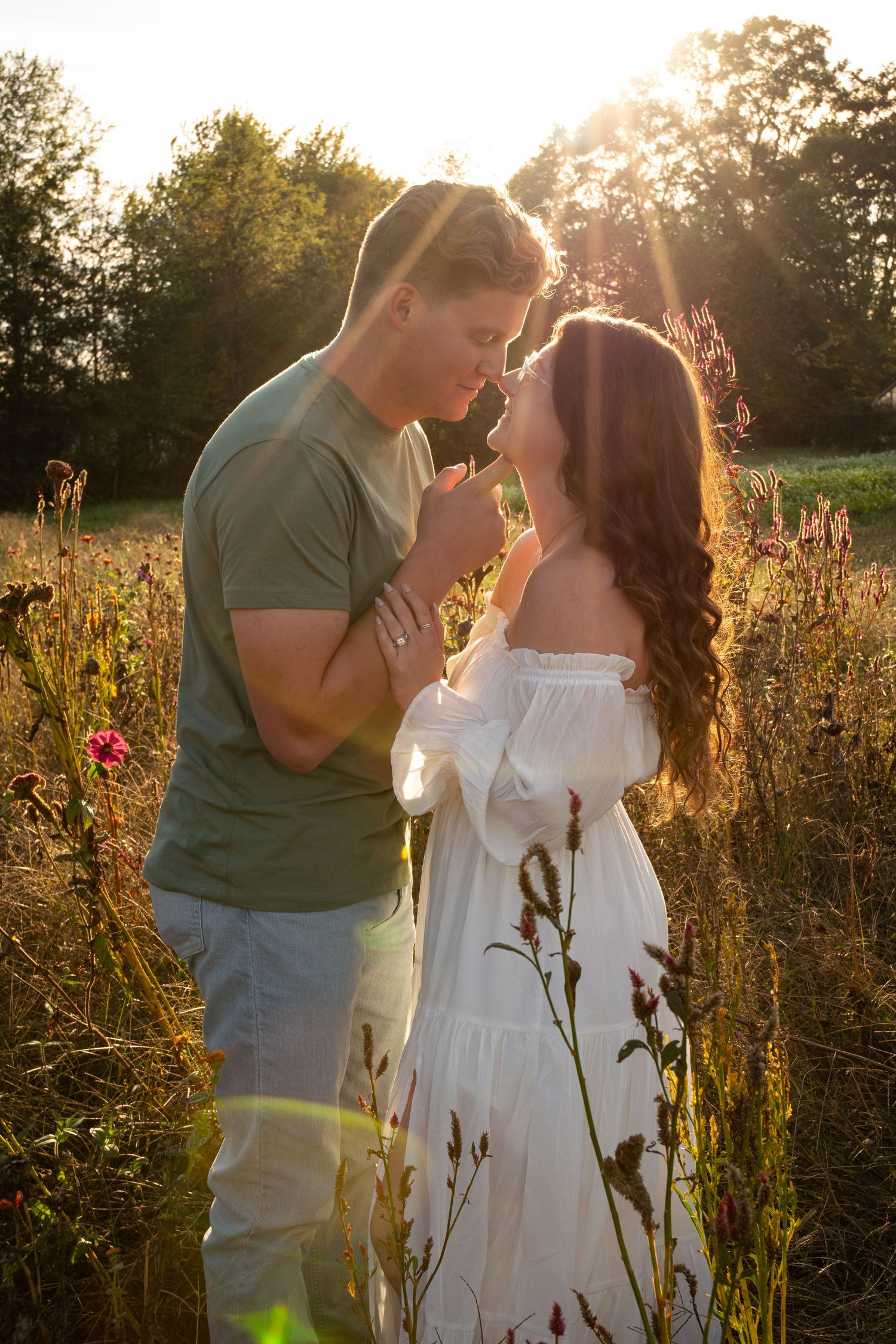 Romantic sunset photoshoot in a wildflower field with golden backlighting.