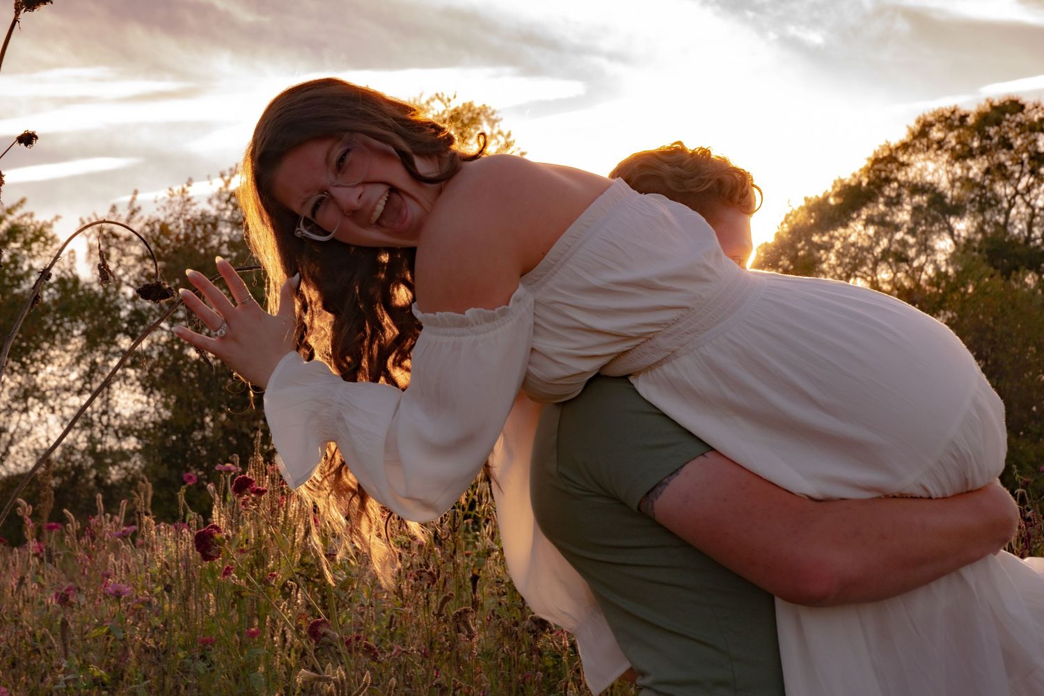 Couple sharing tender moment at sunset with warm golden backlighting.