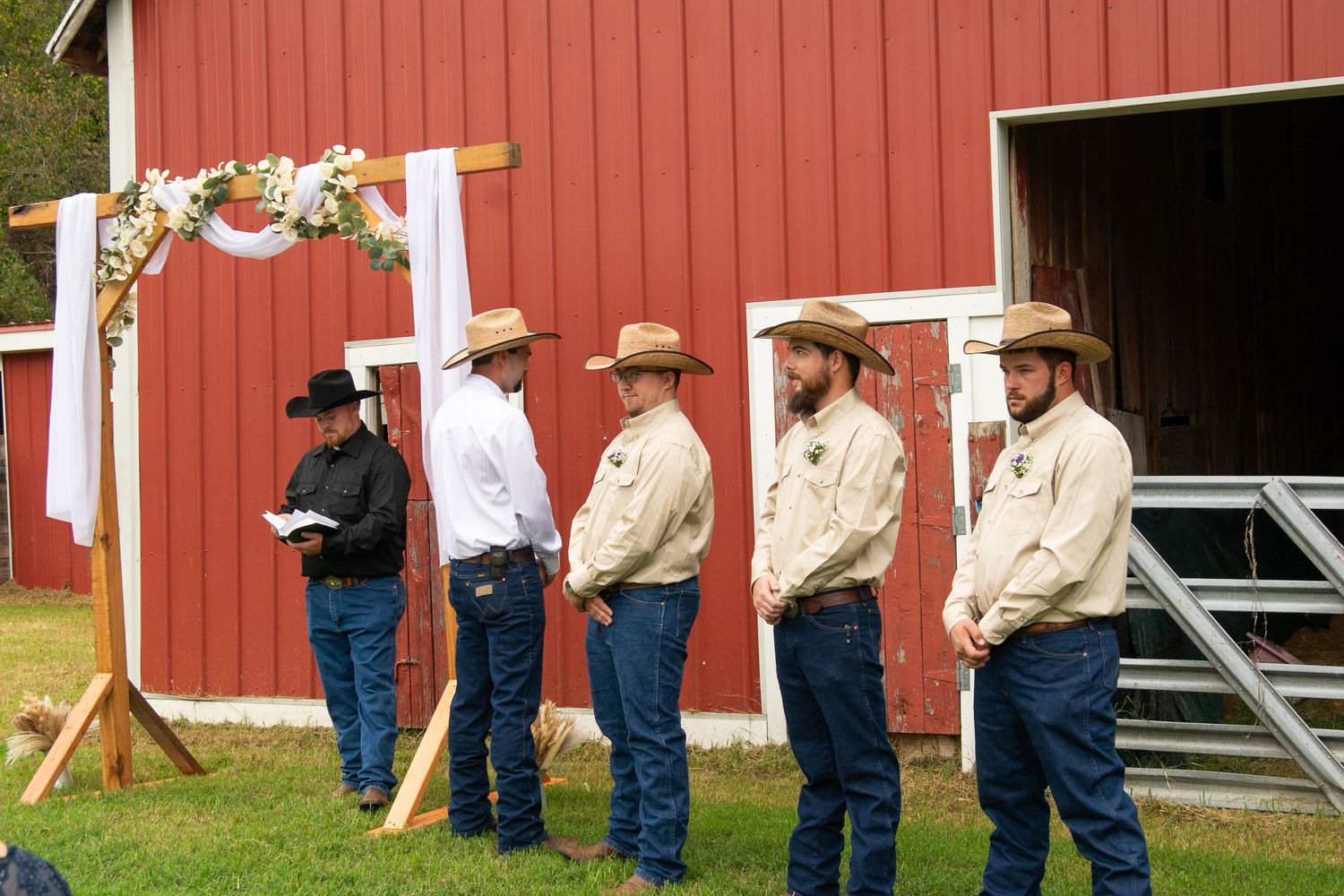A panoramic sequence showing people in western attire standing against a red barn wall outdoors.