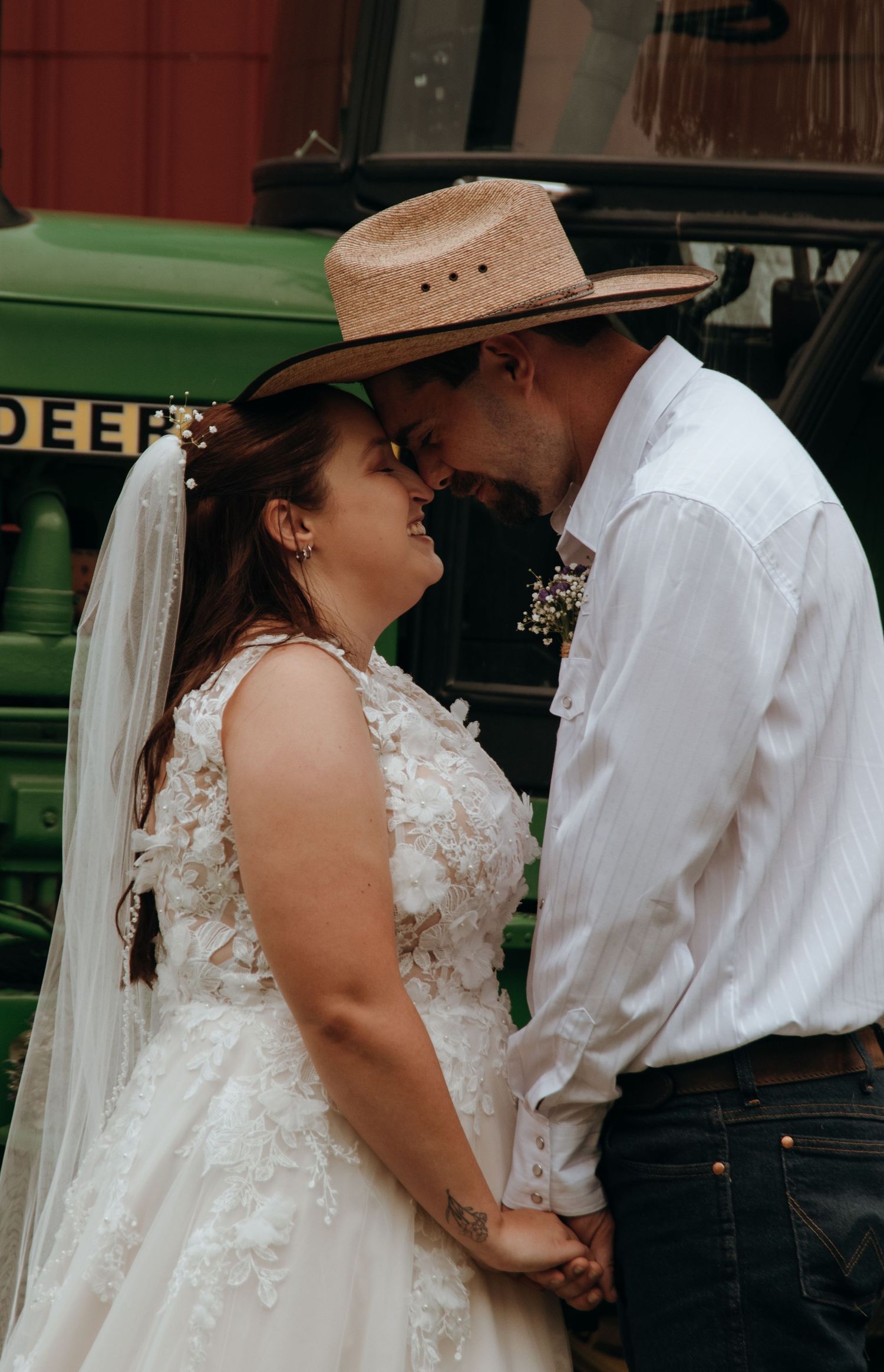Romantic country wedding scene with cowboy hat and lace dress details.