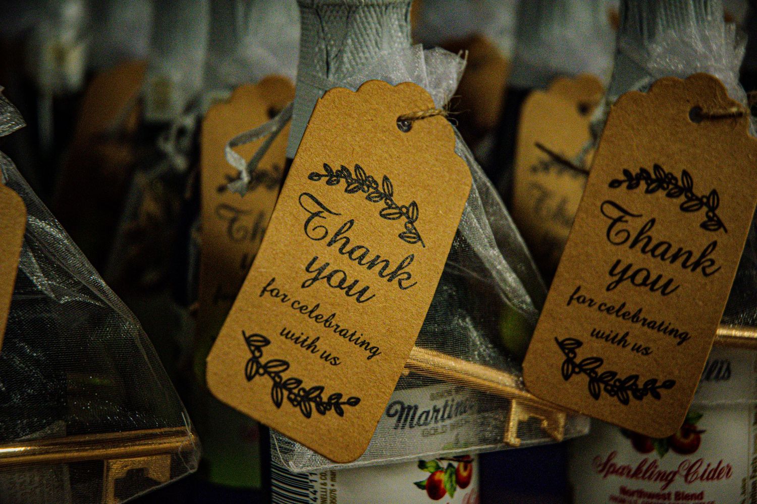 Row of vintage-style thank you tags with floral designs attached to string.