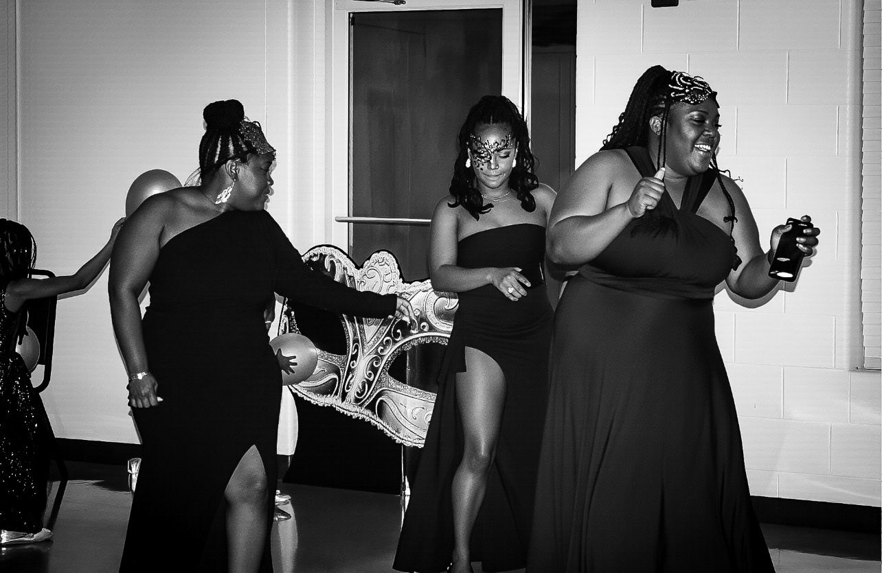 A black and white photo of people dancing and celebrating at what appears to be a party or event.
