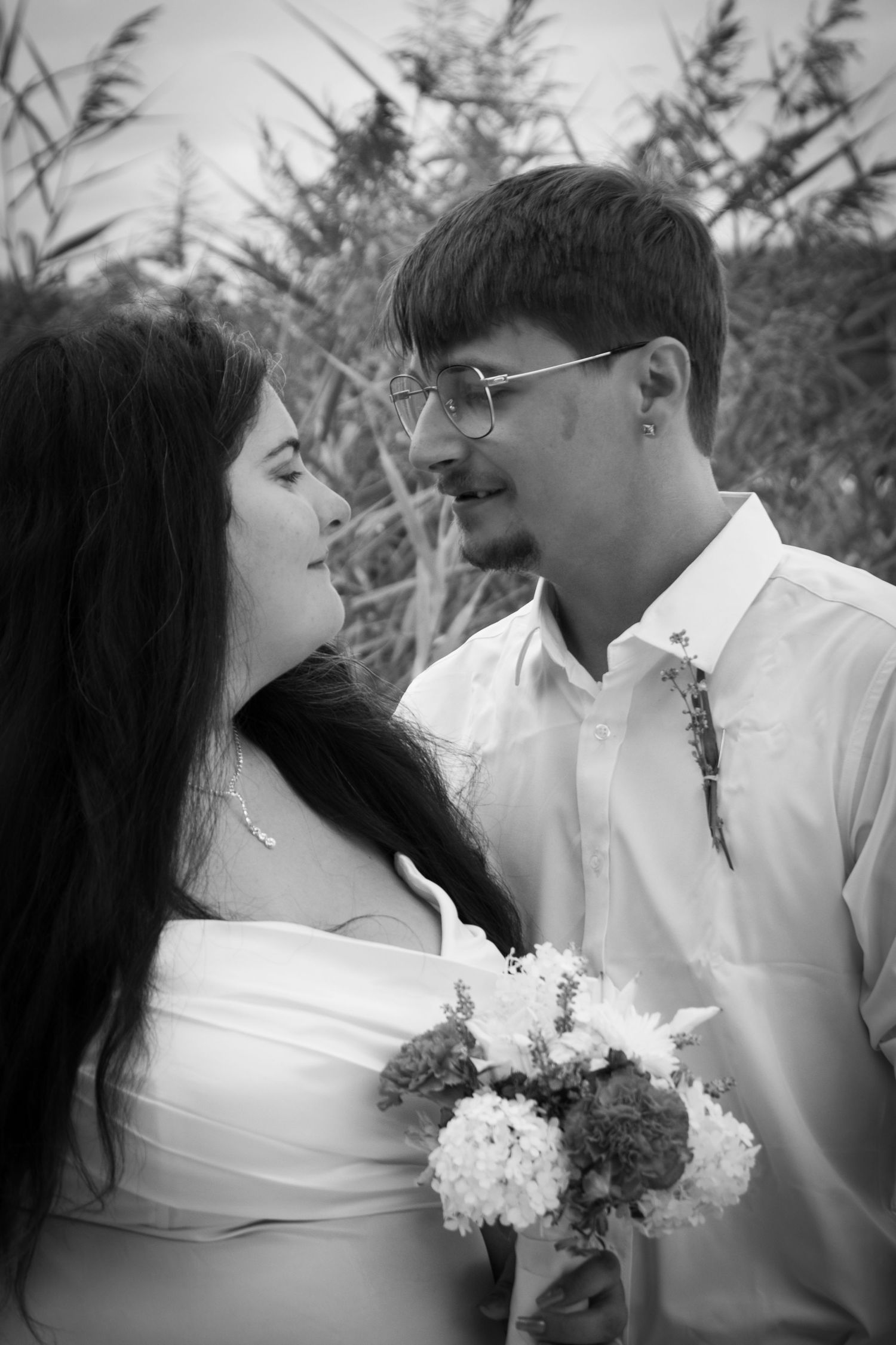 Black and white wedding portraits showing romantic closeups of a couple with white flowers.