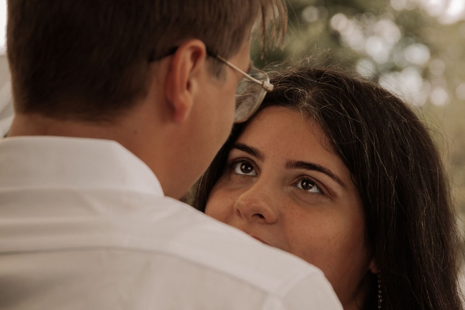 Intimate moment between newlyweds during outdoor wedding ceremony.