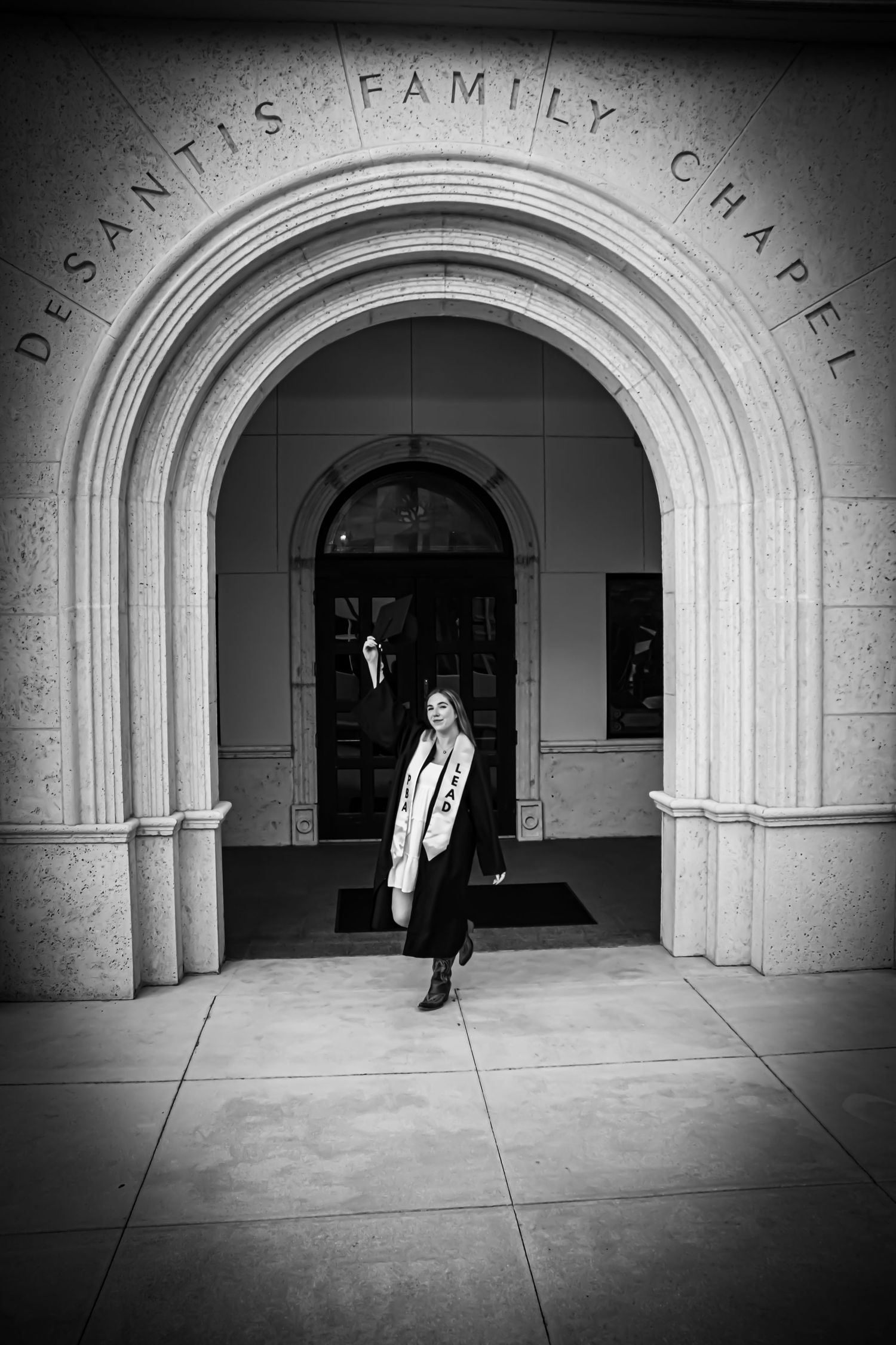 Woman standing in arched entrance of DeSantis Family Chapel in black and white photo.