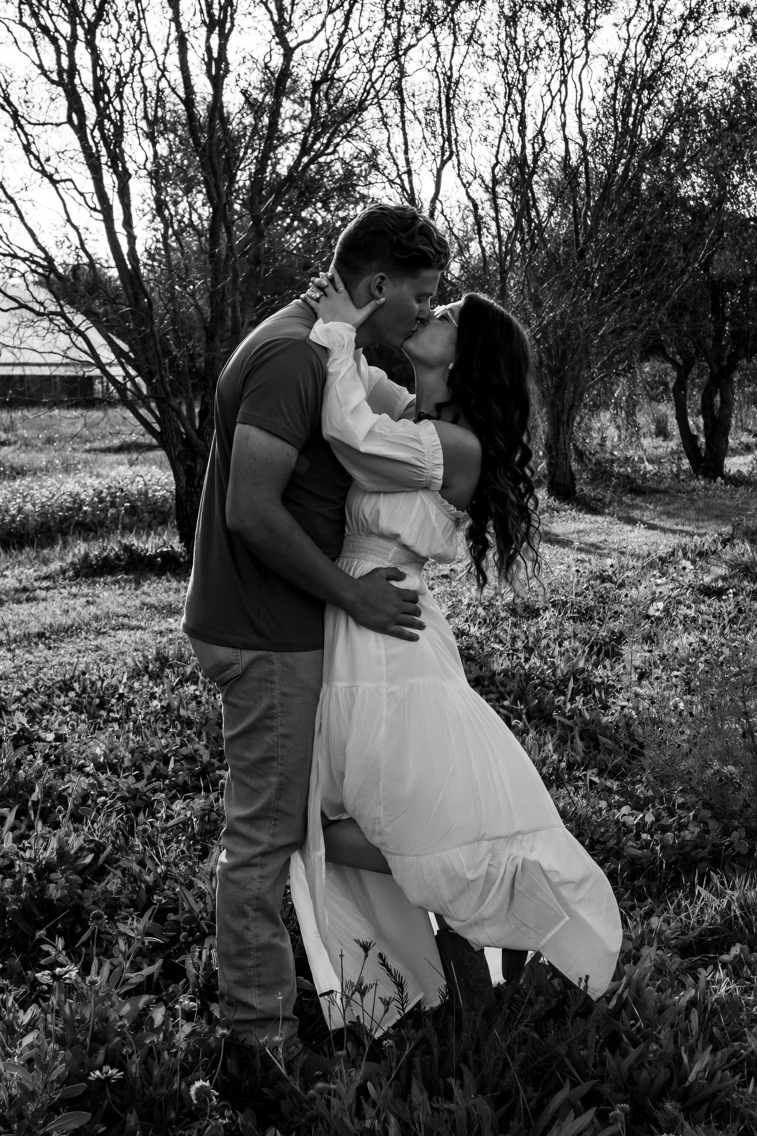 Black and white romantic couple photoshoot in a rustic outdoor setting.