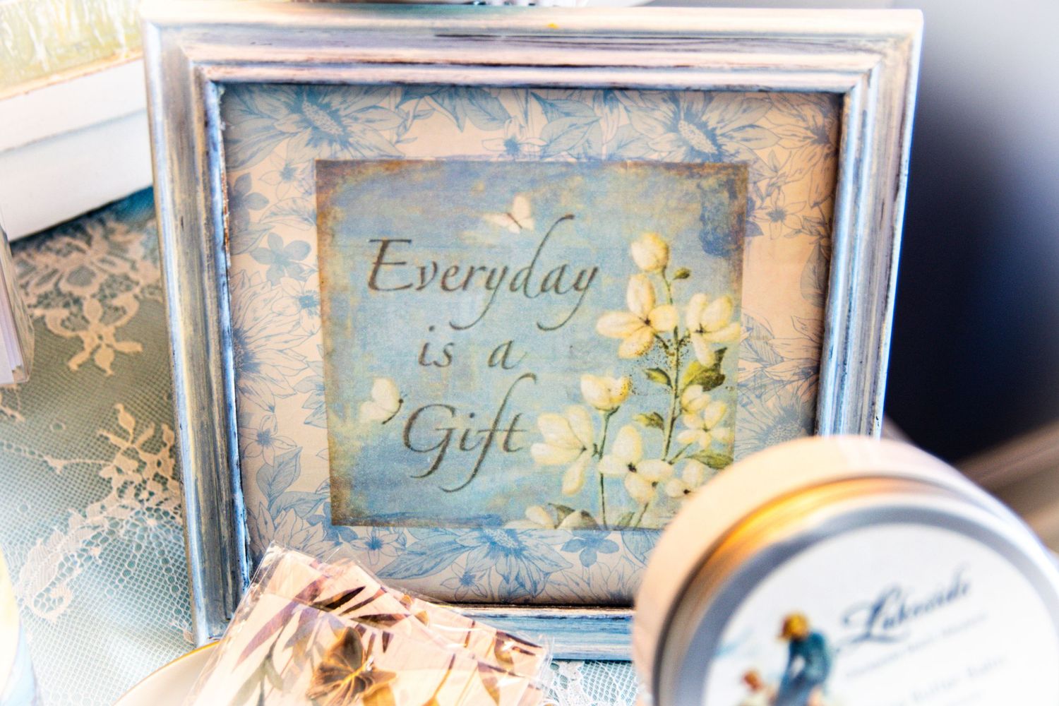 A framed inspirational quote 'Everyday is a Gift' with floral decorations.